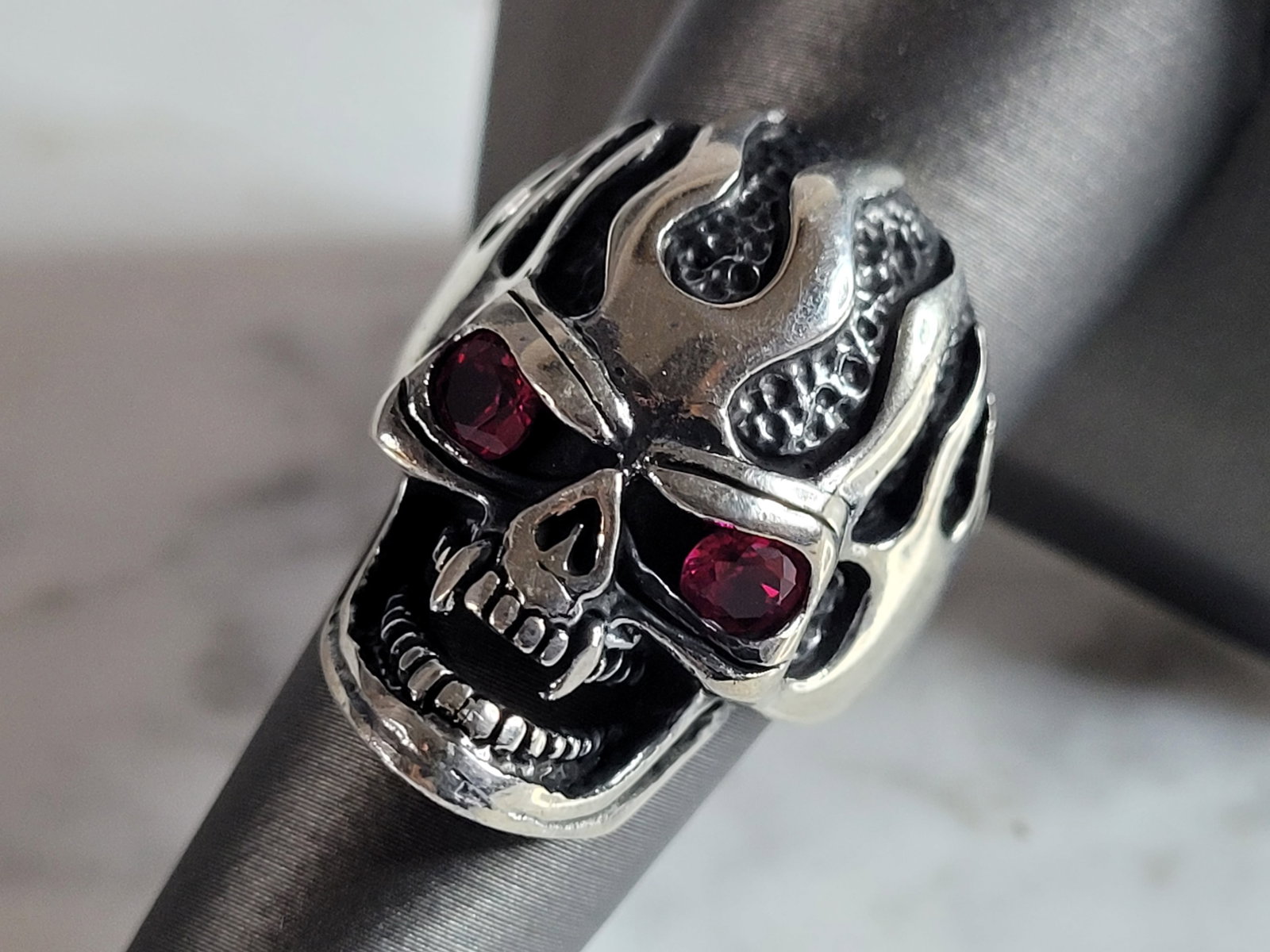 Mens Sterling Silver Ruby Eyed Goth Biker Skull Ring: A MENS STERLING SILVER RUBY EYED SKULL RING. THE TOTAL WEIGHT IS 13.8g, AND IS A SIZE 8.0. THE LENGTH OF THE RING FACE IS 1 1/8". STONES TESTED RUBY ON OUR PRESIDIUM GEM TESTER. THIS RING WOULD MAKE A