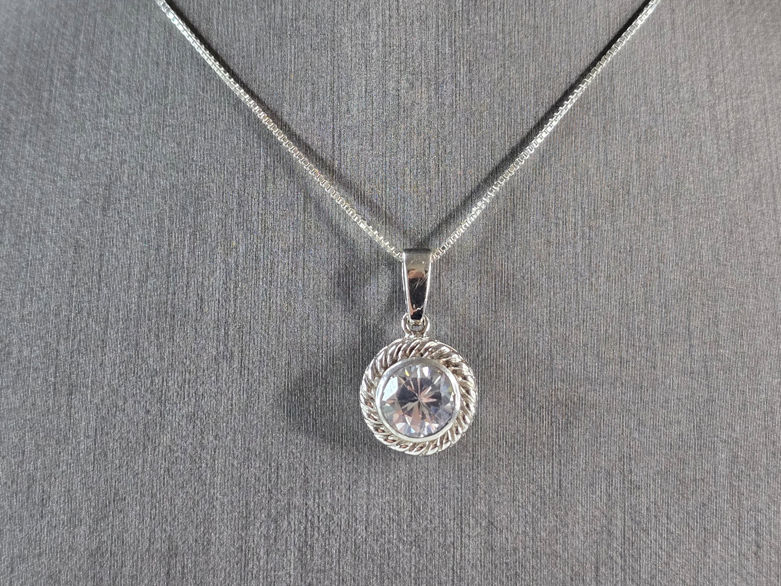 Womens Vintage Estate Sterling Silver CZ Pendant w/ Necklace: A WOMENS VINTAGE ESTATE STERLING SILVER CZ PENDANT WITH NECKLACE. TOGETHER THEY WEIGH 5.5g. THE PENDANT MEASURES 7/8" LONG BY 1/2" WIDE. THE NECKLACE MEASURES 18" LONG. MAKES A GREAT GIFT FOR THAT SOM