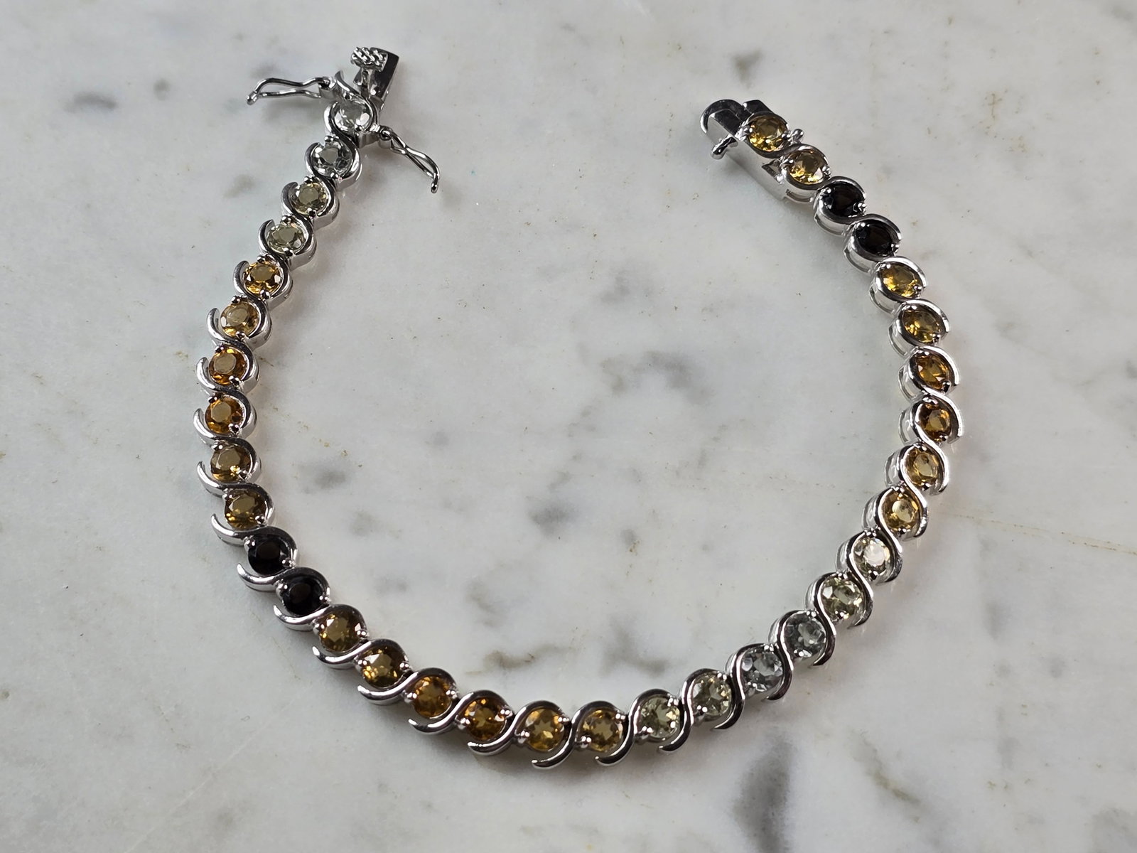 Womens Sterling Silver Modernist Citrine Quartz Topaz Bracelet: A WOMENS VINTAGE ESTATE STERLING SILVER BRACELET WITH CITIRINE, SMOKY QUARTZ, AND TOPAZ COLORED STONES. BRACELET IS ABOUT 7 3/4" LONG BY 1/4" WIDE AND WEIGHS 17.3g. NOT SURE IF STONES ARE NATURAL OR M