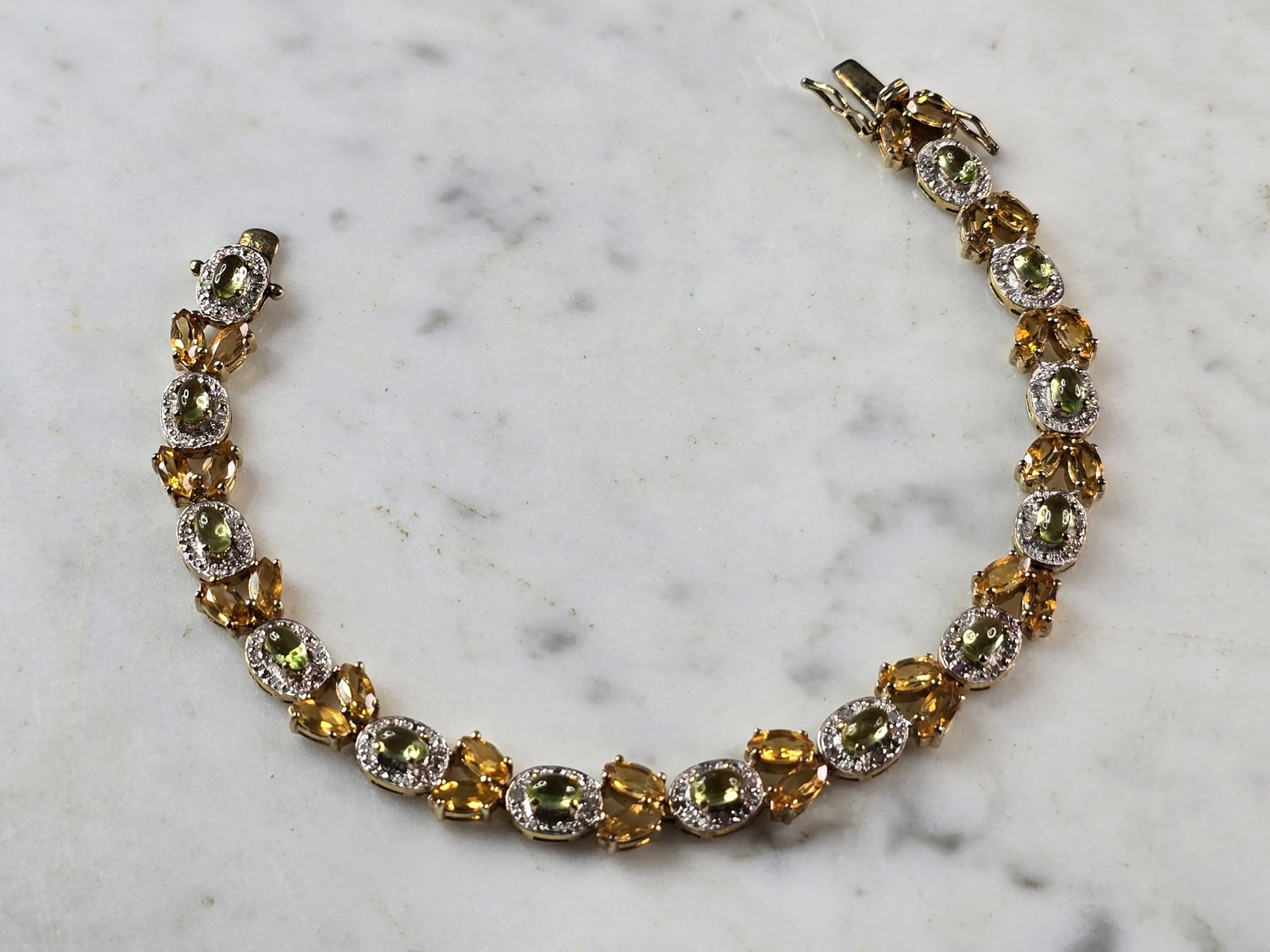 Womens Sterling Silver Gold Tone Citrine Peridot Bracelet: A WOMENS VINTAGE ESTATE STERLING SILVER GOLD TONE BRACELET WITH CITIRINE & PERIDOT COLORED STONES. BRACELET IS ABOUT 7 5/8" LONG BY 3/8" WIDE AND WEIGHS 16.2g. NOT SURE IF STONES ARE NATURAL OR MAN MA