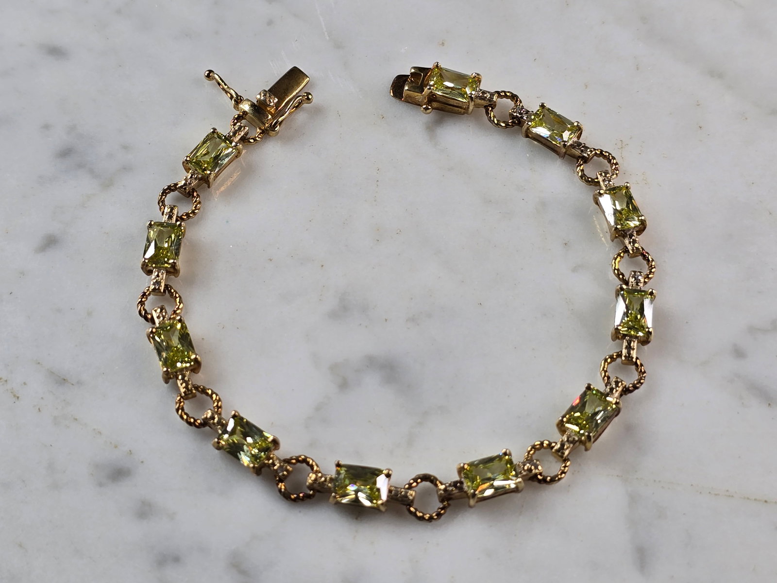 Womens Sterling Silver Gold Tone Peridot Bracelet: A WOMENS VINTAGE ESTATE STERLING SILVER GOLD TONE BRACELET WITH PERIDOT COLORED STONES. BRACELET IS ABOUT 7 3/4" LONG BY 1/4" WIDE AND WEIGHS 13.3g. NOT SURE IF STONES ARE NATURAL OR MAN MADE. WOULD M