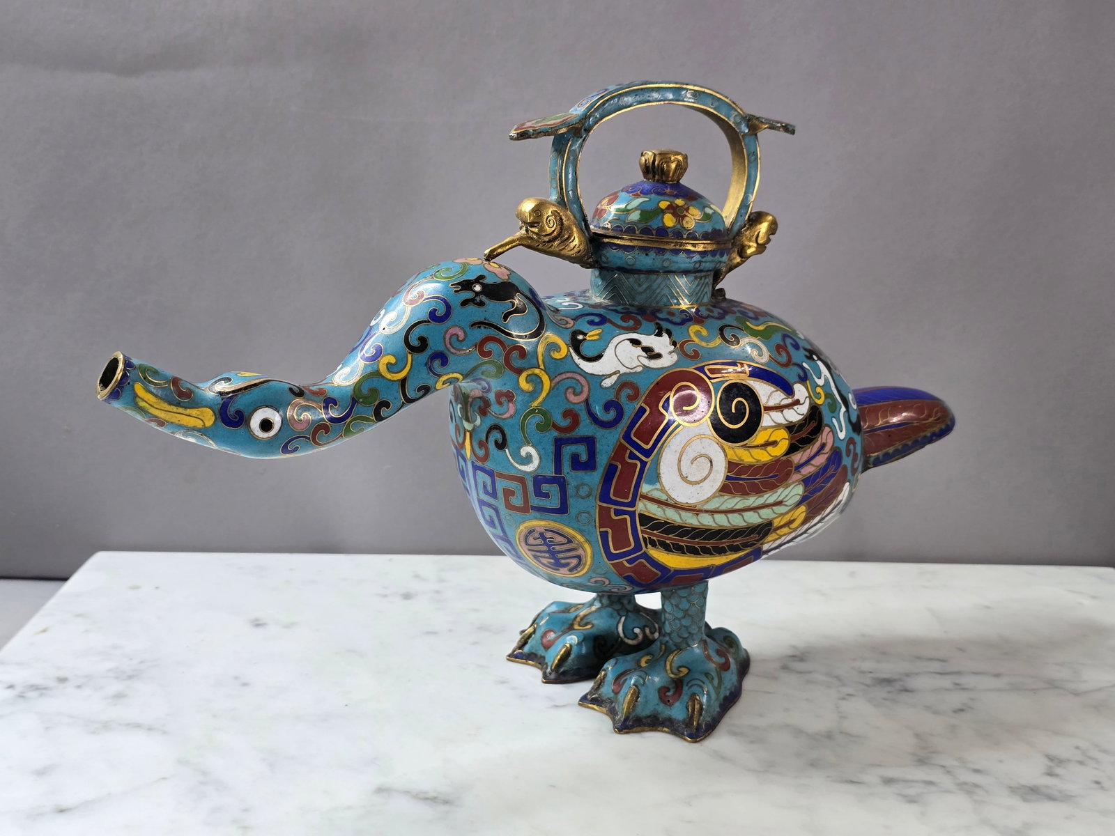 VINTAGE ANTIQUE CHINESE CLOISONNE DUCK TEAPOT: A BEAUTIFUL VINTAGE ANTIQUE CHINESE CLOISONNE DUCK TEAPOT THAT MEASURES 12 3/4" LONG BY 8" TALL BY 4" WIDE. CONDITION LOOKS VERY NICE. I DO KNOW THAT WHEN THESE PIECES ALONG WITH THE OTHER CLOISONNE T