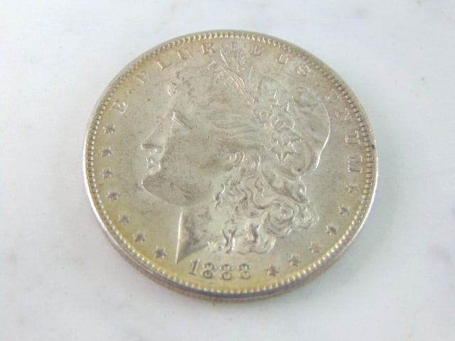 COLLECTIBLE 1888 MORGAN SILVER DOLLAR W/ TONING: AN 1888 MORGAN SILVER DOLLAR WITH SLIGHT TONING ALONG THE EDGE WITH A LITTLE MORE ON THE BACK. BUYING AS IS.