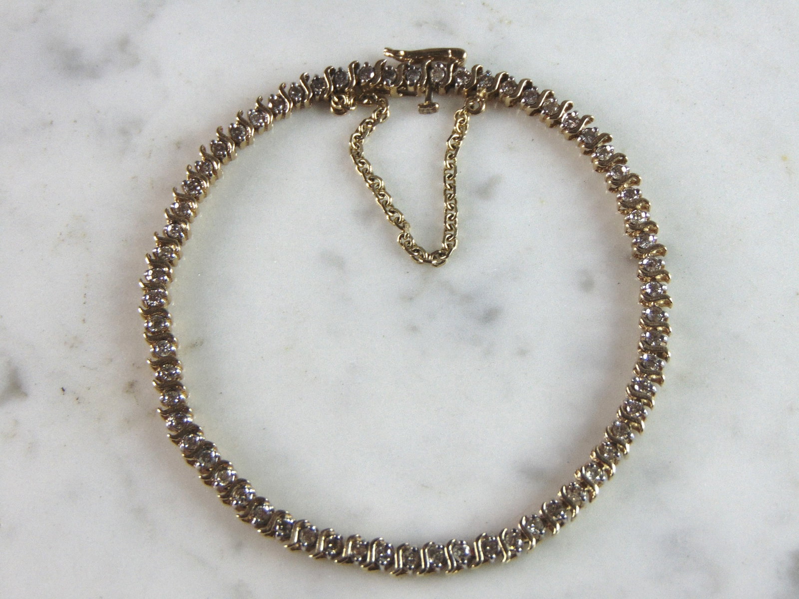 Womens Vintage Estate 14K Yellow Gold Diamond Tennis Bracelet: A WOMENS VINTAGE ESTATE 14K YELLOW GOLD DIAMOND TENNIS BRACELET WITH ABOUT .63cts IN DIAMONDS. THE BRACELET MEASURES 7" LONG BY 1/8" WIDE. AND WEIGHS 9.5g. WOULD MAKE A GREAT GIFT FOR THAT SPECIAL SOM