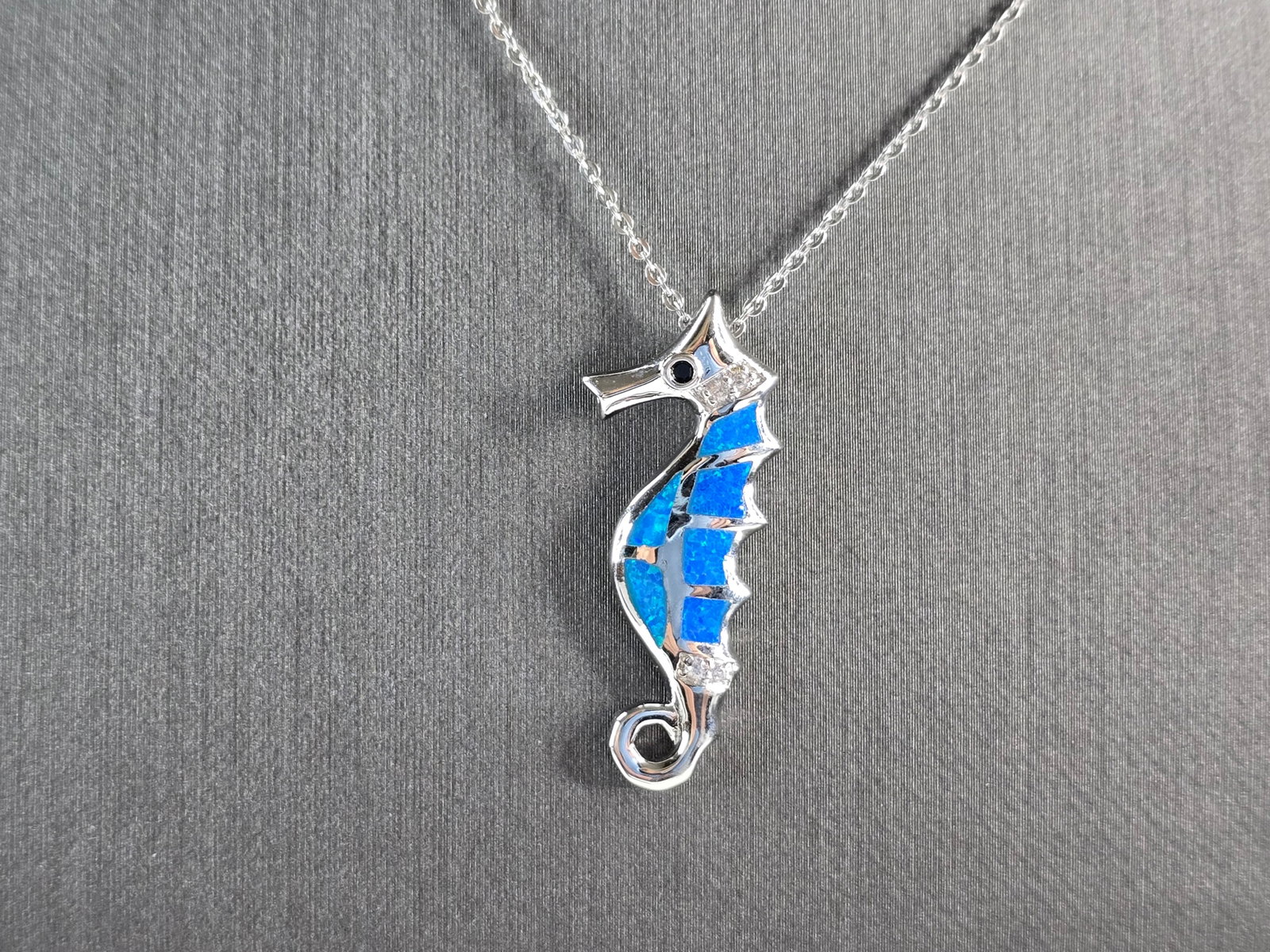 Womens Sterling Silver Blue Opal Seahorse Pendant Necklace: A WOMENS STERLING SILVER BLUE OPAL SEAHORSE PENDANT. THE PENDANT WITH NECKLACE WEIGHS 4.5g. THE PENDANT MEASURES 1 1/4" LONG BY 1/2" WIDE, AND THE NECKLACE MEASURES 18" LONG. NOT SURE IF STONES ARE RE