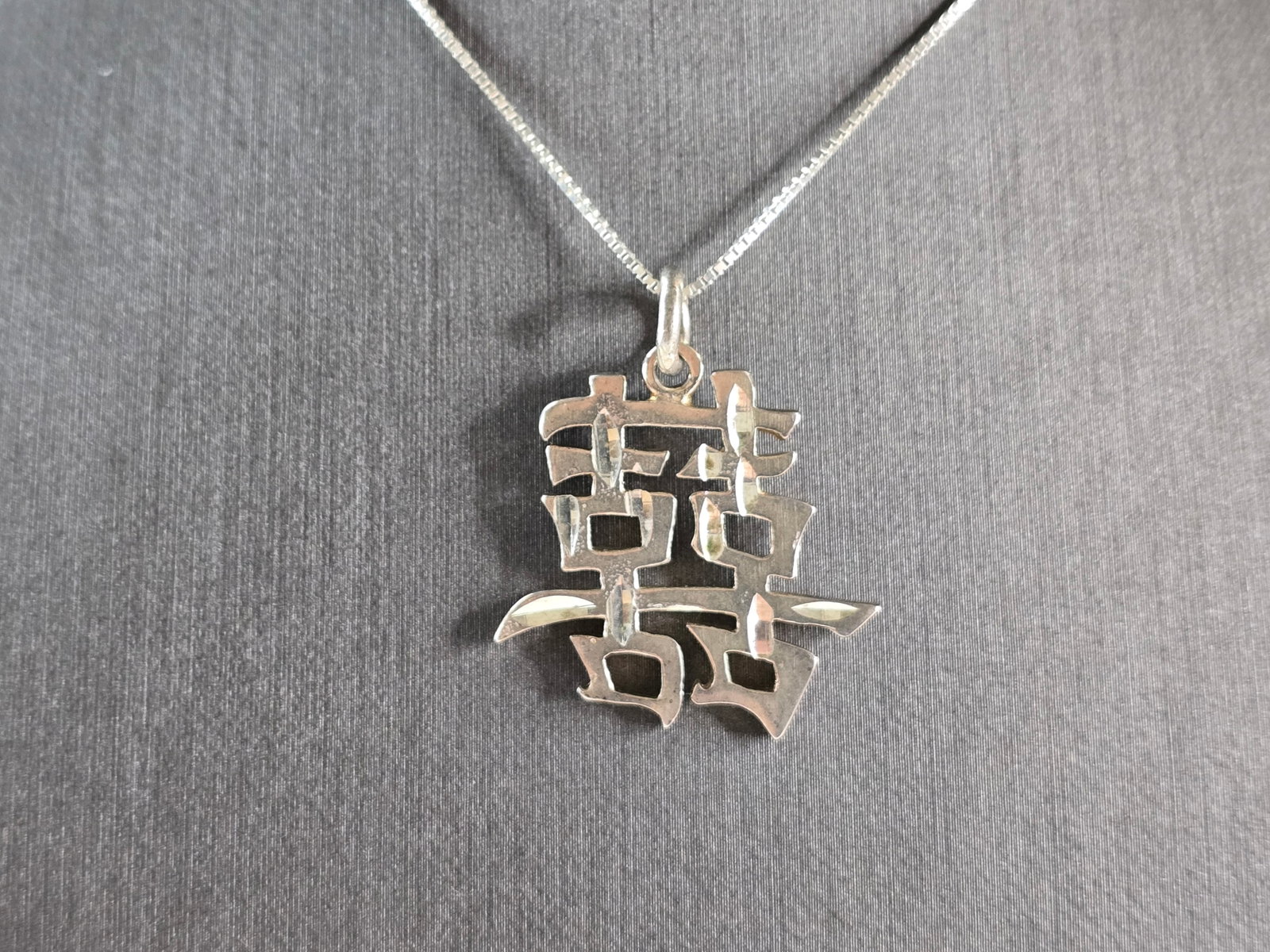 Sterling Silver Chinese Symbol Double Happiness Pendant Necklace: A VINTAGE ESTATE STERLING SILVER CHINESE SYMBOL WHICH BELIEVE MEANS "DOUBLE HAPPINESS". PENDANT WITH NECKLACE WEIGHS 7.8g. THE NECKLACE MEASURES 18", AND THE PENDANT MEASURES 1 1/4" LONG BY 1" WIDE. M