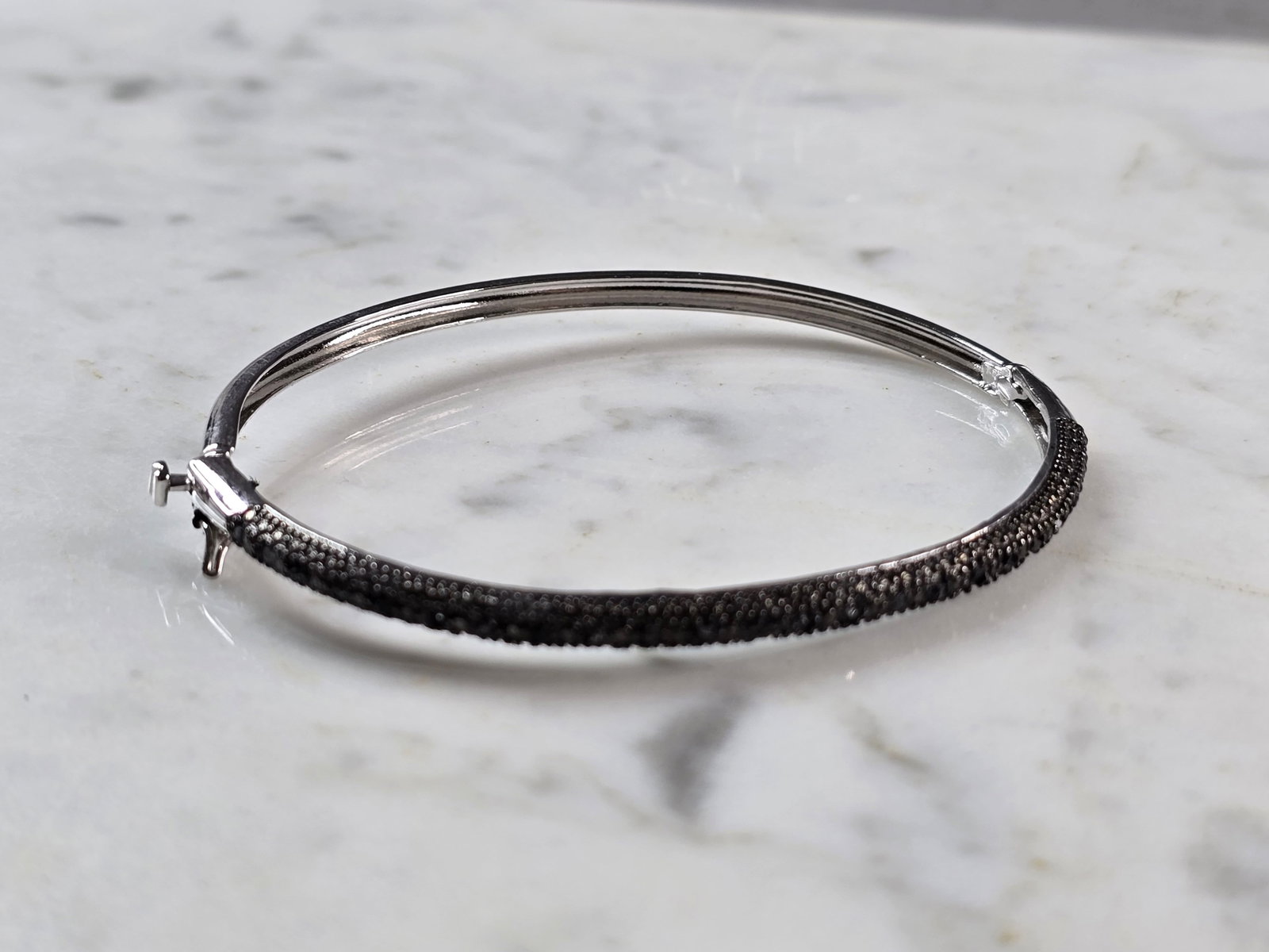 Womens Vintage Estate Sterling Silver Bangle Bracelet: A WOMENS VINTAGE ESTATE STERLING SILVER BANGLE BRACELET. BRACELET MEASURES 7" IN CIRCUMFRANCE BY 1/8" WIDE, AND WEIGHS 7.7g. BRACELET HAS ONYX COLORED STONES. STONES ARE MAN MADE. THIS WOULD MAKE A LO