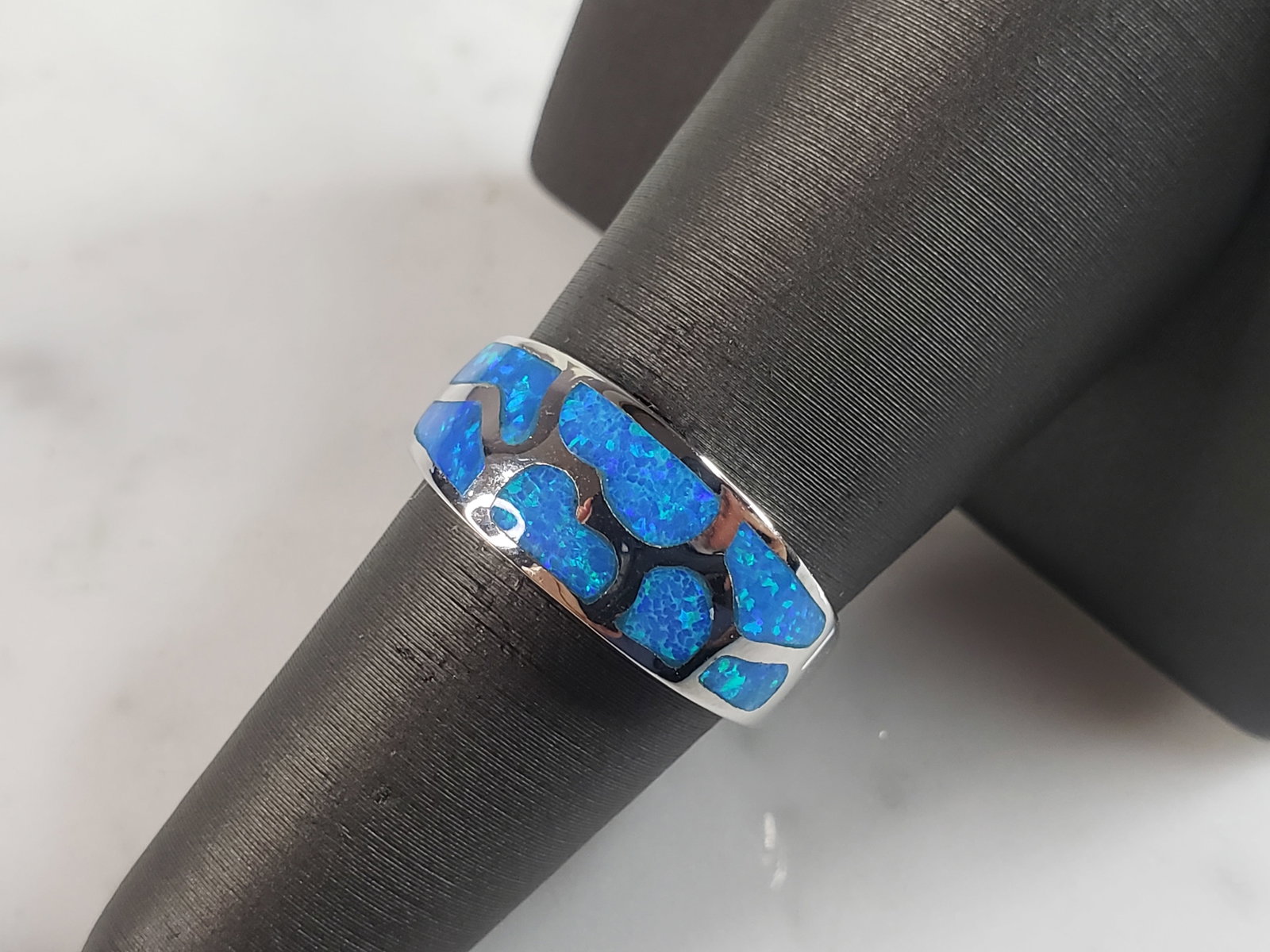 Womens Estate Sterling Silver Modernist Blue Opal Ring: A WOMENS ESTATE STERLING SILVER MODERNIST BLUE OPAL COLORED RING. THE RING IS A SIZE 6.0, AND WEIGHS 4.5g. WIDTH OF RING MEASURES 3/8". NOT SURE IF STONE IS NATURAL OR MAN MADE. THE RING MAKES A BEAUT