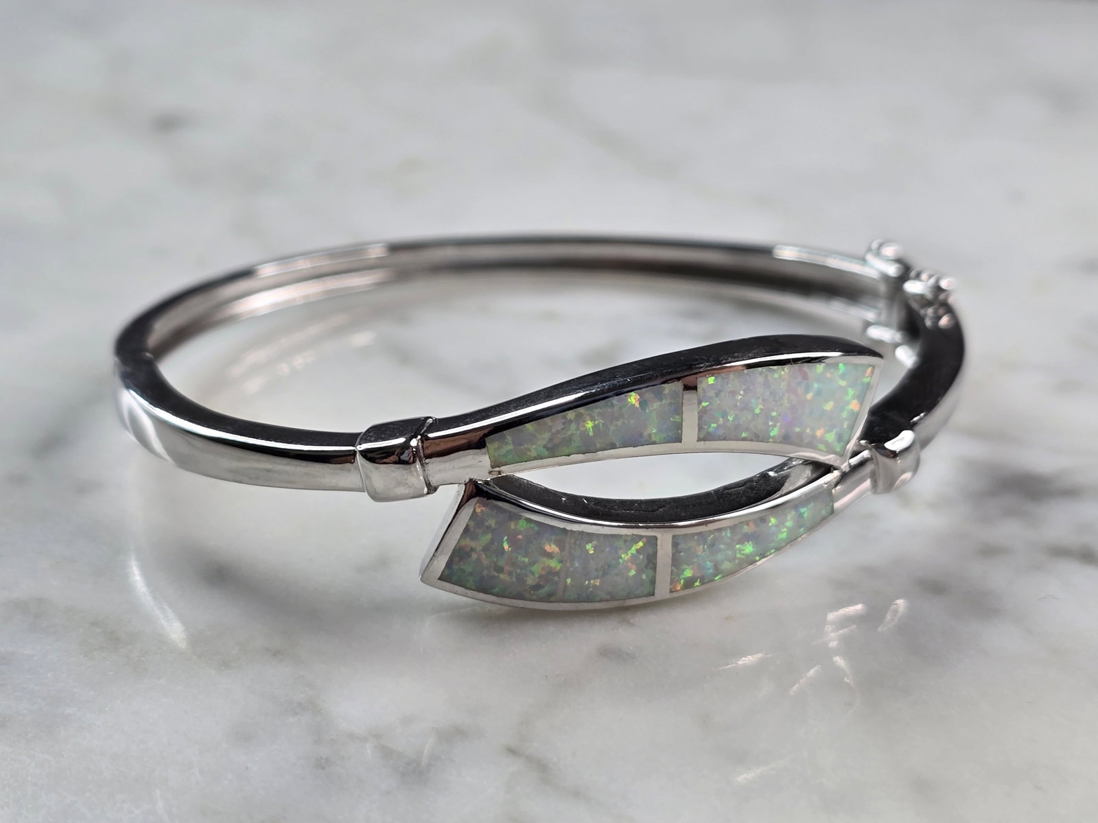 Womens Sterling Silver Modernist Opal Bangle Bracelet: A WOMENS STERLING SILVER MODERNIST OPAL COLORED BANGLE BRACELET. THE BRACELET WEIGHS 17.3g AND IS ABOUT 3/4" WIDE. THE CIRCUMFERENCE 6 1/2". NOT SURE IF STONE IS NATURAL OR MAN MADE. ANY QUESTIONS PLE
