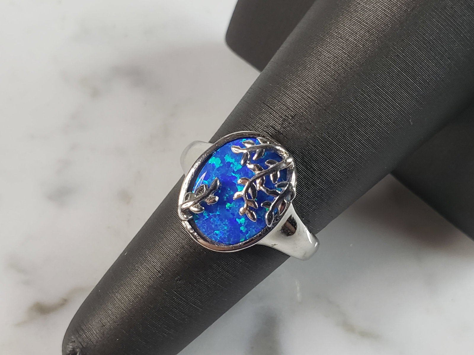 Womens Estate Sterling Silver Modernist Blue Opal Ring: A WOMENS ESTATE STERLING SILVER MODERNIST BLUE OPAL COLORED RING. THE RING IS A SIZE 6.0 AND WEIGHS 4.8g. WIDTH OF RING MEASURES 5/8". NOT SURE IF STONE IS NATURAL OR MAN MADE. THE RING MAKES A BEAUTI