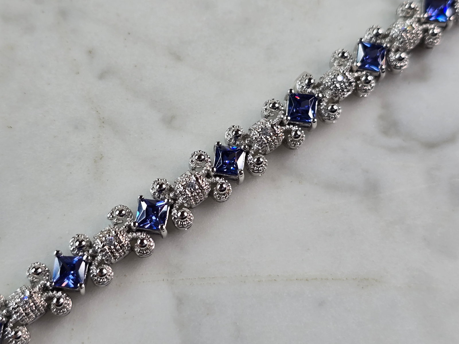 Womens Vintage Estate Sterling Silver Tanzanite Bracelet: A WOMENS VINTAGE ESTATE STERLING SILVER TANZANITE COLORED BRACELET. NOT SURE IF STONES ARE NATURAL OR MAN MADE. BRACELET MEASURES 7 1/2" LONG BY 3/8" WIDE, AND WEIGHS 21.9g. THIS WOULD MAKE A LOVELY G