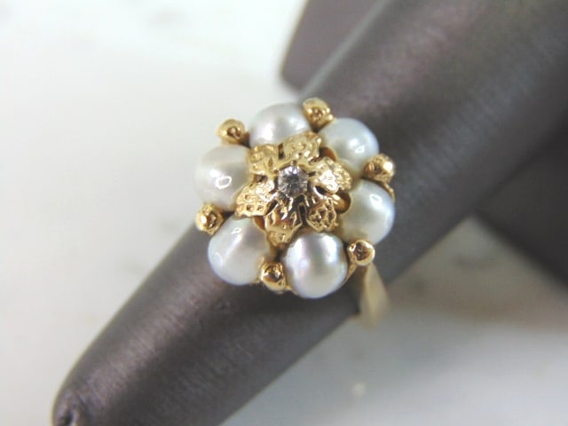 Womens Vintage Estate 14K Gold Pearl & Diamond Ring: A WOMENS VINTAGE ESTATE 14K GOLD PEARL & DIAMOND RING. THE RING IS A SIZE 5.75, AND WEIGHS 8.7g. THE DIAMOND IS ABOUT .05cts. NOT SURE IF THE PEARLS ARE REAL OR MAN MADE. SETTING OF THE RING IS GORGEO