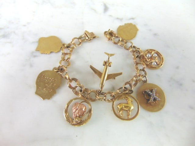 Womens Vintage Estate 14k Gold Charm Bracelet: A WOMENS VINTAGE ESTATE 14k GOLD CHARM BRACELET. THE BRACELET WEIGHS 33.8g, AND MEASURES 7" LONG. ALL ARE MARKED 14K EXCEPT FOR ONE OF THE CHILD TAGS AND THE ONE WITH ROSE GOLD. THE GRAPE LEAF ROSE GO