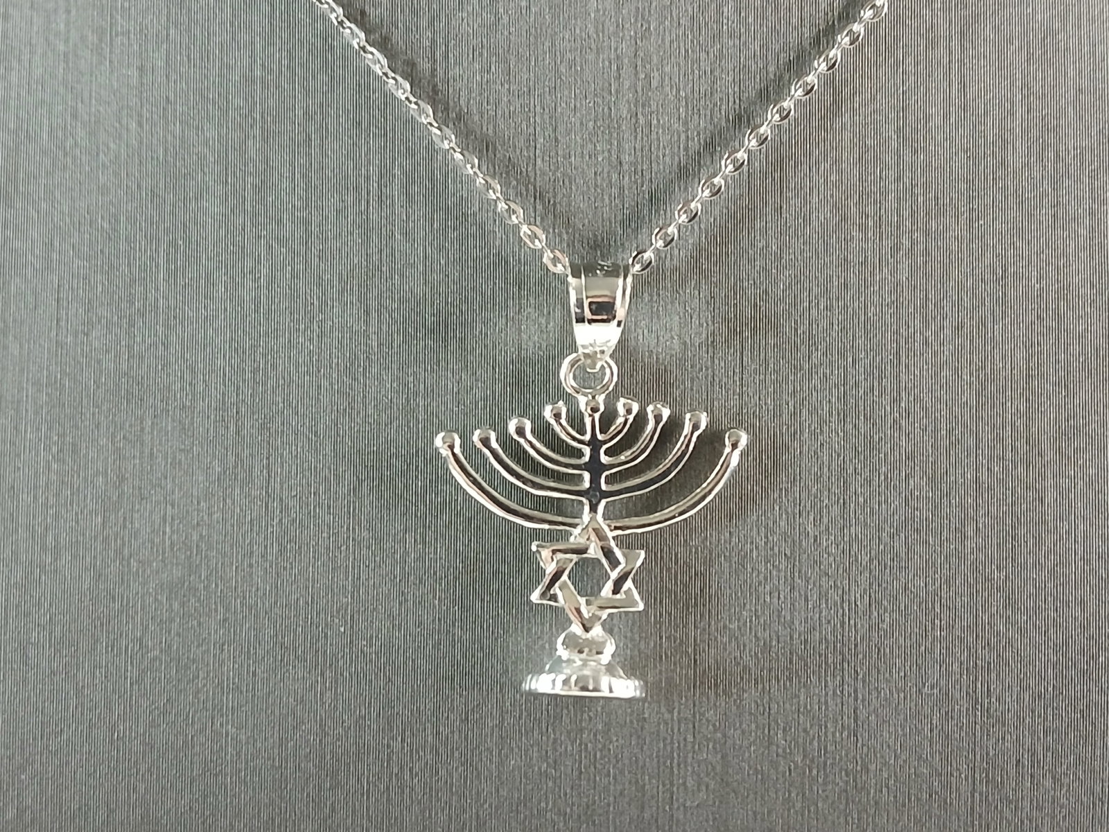 Womens Sterling Silver Jewish Judaica Hebrew Menorah Pendant Necklace: A WOMENS STERLING SILVER JEWISH HEBREW MENORAH PENDANT NECKLACE. PENDANT WITH NECKLACE WEIGHS 3.7g. THE PENDANT MEASURES 1" LONG BY 3/4" WIDE. THE NECKLACE MEASURES 18" LONG AND IS ADJUSTABLE TO 16". 