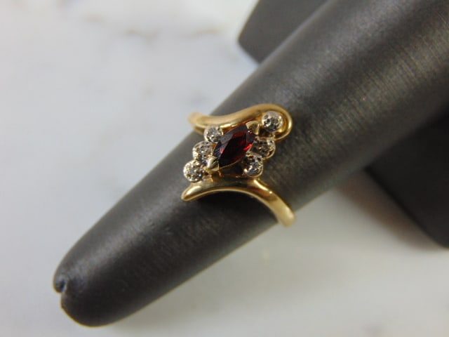 Womens Vintage 10k Gold Ring w/ Ruby & Diamonds: A BEAUTIFUL VINTAGE ESTATE WOMENS 10K GOLD RING WITH A RUBY COLORED CENTER STONE ACCENTED WITH DIAMOND CHIPS. THE RING WEIGHS 2.7g. SIZE OF THE RING IS A 5.75. RUBY IS NOT REAL. ANY OTHER QUESTIONS PL
