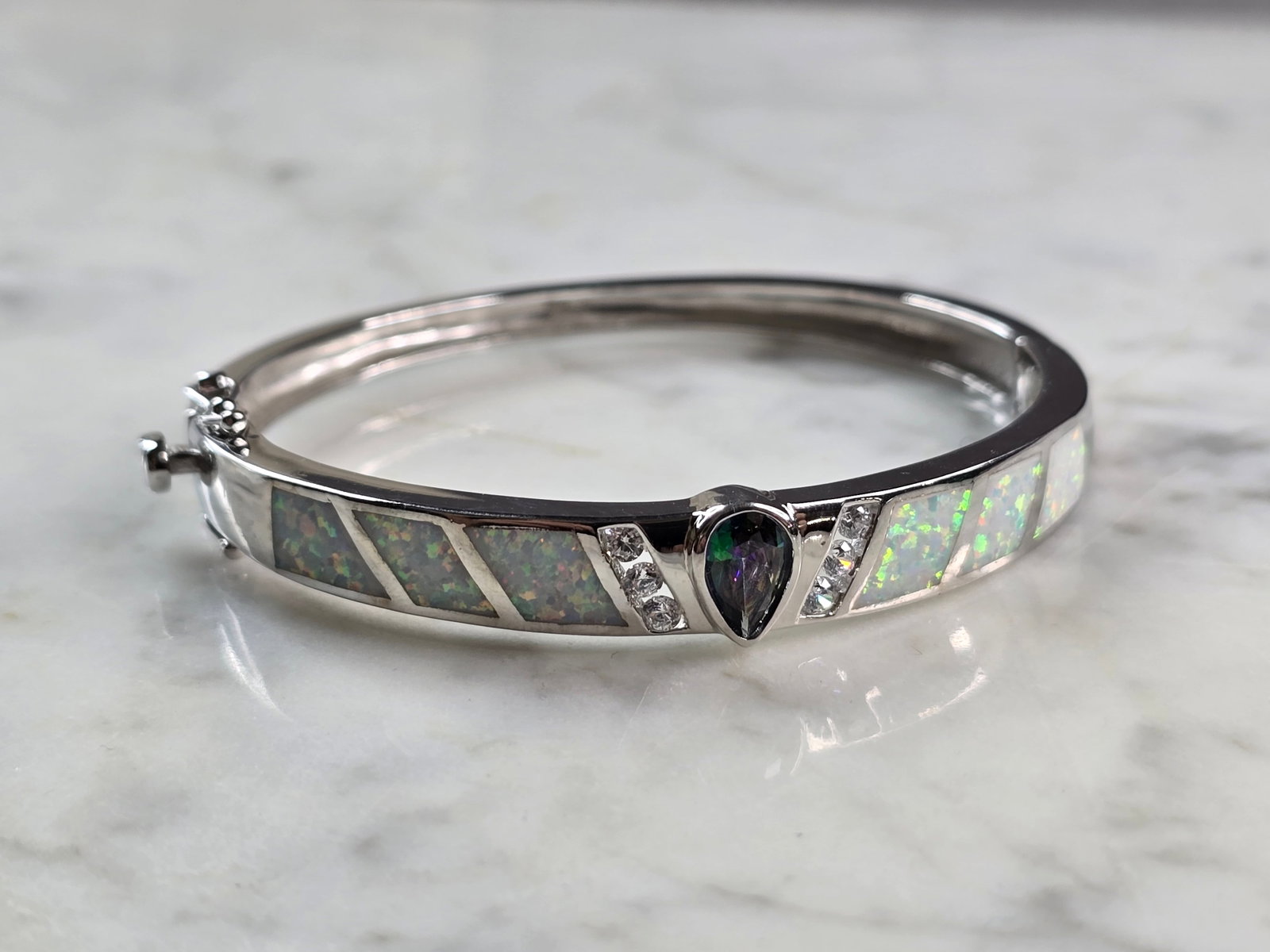 Womens Sterling Silver Modernist Opal Bangle Bracelet: A WOMENS STERLING SILVER MODERNIST OPAL BANGLE BRACELET WITH A MYSTIC TOPAZ COLORED STONE. THE BRACELET WEIGHS 20.0g AND IS ABOUT 3/8" WIDE. THE CIRCUMFERENCE IS 6 1/2". NOT SURE IF THE OPAL IS REAL O