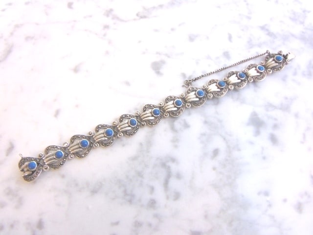 Womens Vintage Sterling Silver Bracelet w/ Turquoise: FOR SALE IS THIS LOVELY WOMENS VINTAGE ESTATE STERLING SILVER BRACELET THAT HAS TURQUOISE COLORED STONES. THE BRACELET MEASURES 7" LONG BY 1/2" WIDE, AND WEIGHS 31.6g. NOT SURE IF THE STONES ARE REAL 