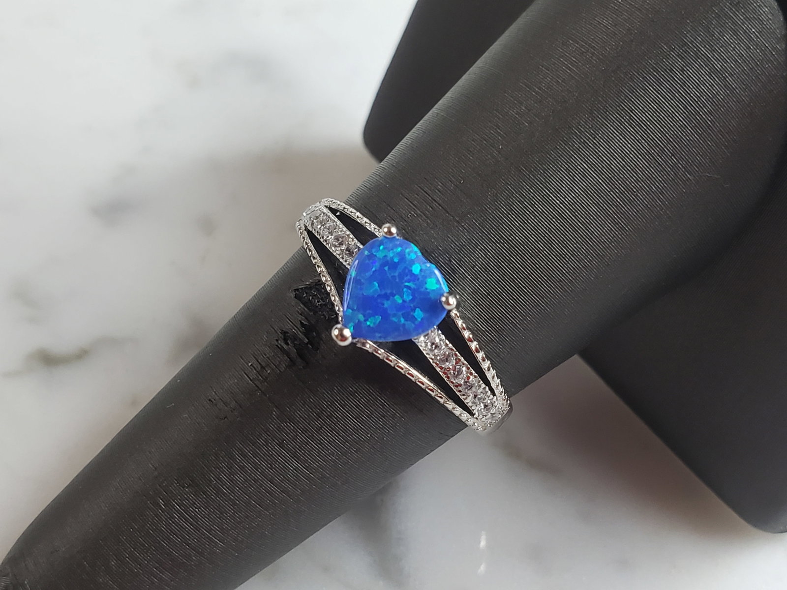 Womens Estate Sterling Silver Modernist Blue Opal Heart Ring: A WOMENS ESTATE STERLING SILVER MODERNIST OPAL COLORED HEART RING. THE RING IS A SIZE 7.0, AND WEIGHS 1.9g. WIDTH OF RING MEASURES 3/8". NOT SURE IF STONE IS NATURAL OR MAN MADE. THE RING MAKES A BEAU