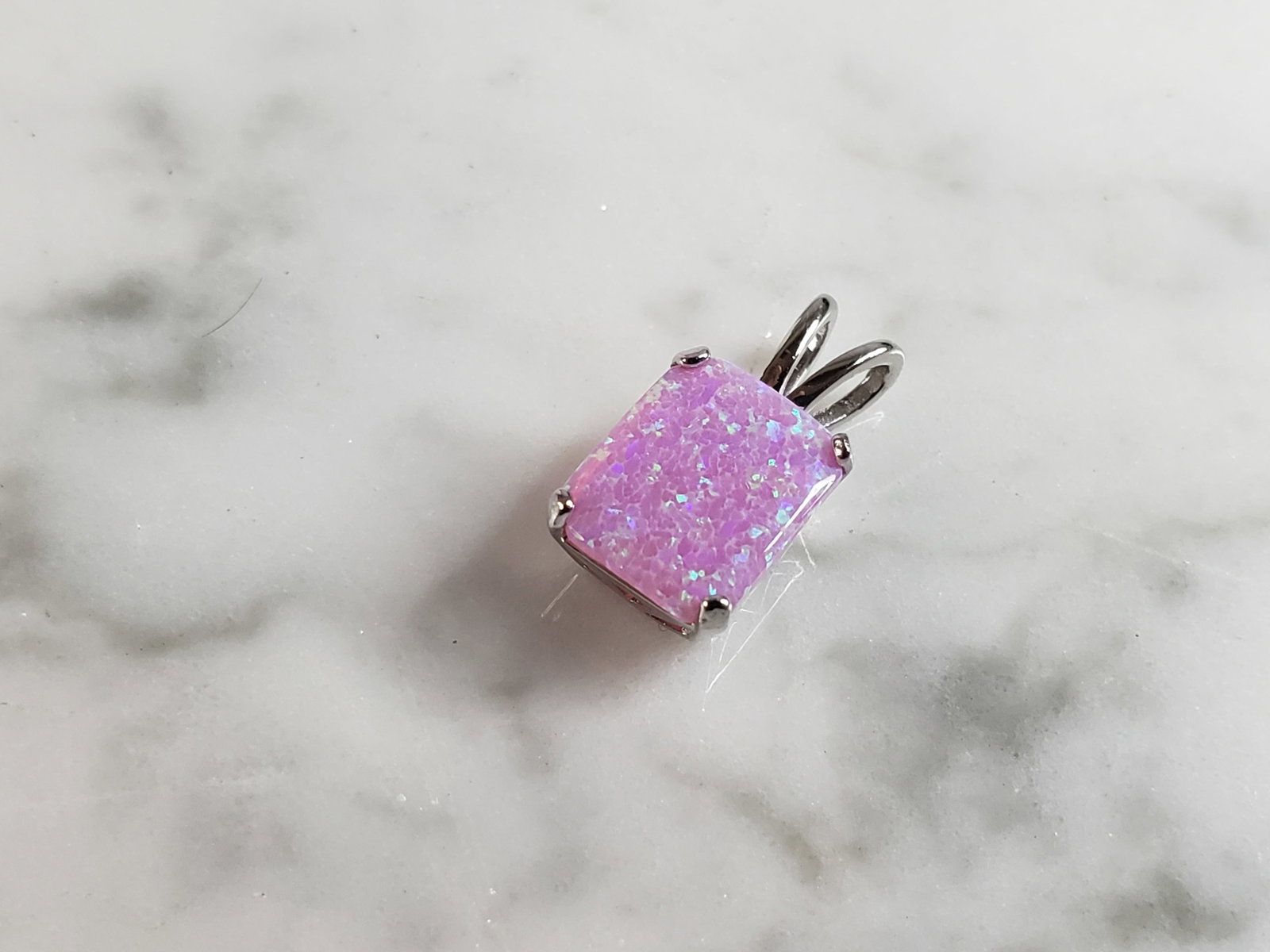 Womens Vintage Estate Sterling Silver Pink Opal Stone Pendant: A WOMENS ESTATE STERLING SILVER PINK OPAL STONE PENDANT. NOT SURE IF STONES ARE REAL OR MAN MADE. THE PENDANT WEIGHS 1.1g AND MEASURES 5/8" LONG BY 1/4" WIDE. MAKES A GREAT GIFT FOR THAT SOMEONE SPECI