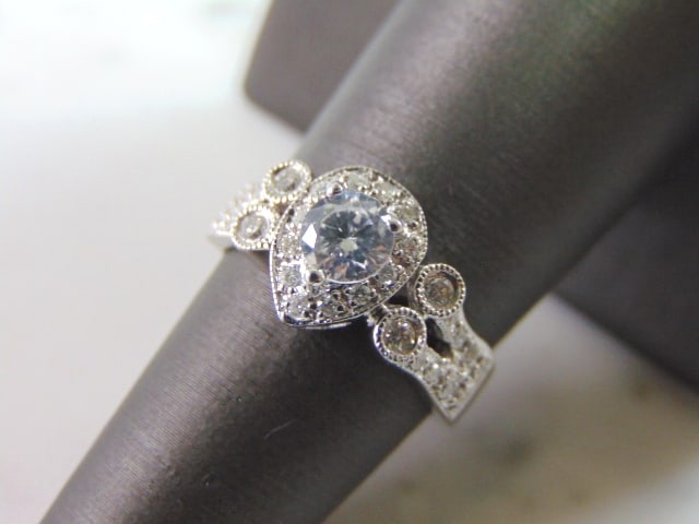 Womens Vintage Estate 18k White Gold Diamond Ring: A WOMEN'S 18K WHITE GOLD DIAMOND RING WITH ABOUT 0.60cts. THE RING WEIGHS 5.2g. THE SIZE OF THE RING IS A 6.75. RING IS STAMPED ON THE INSIDE "18K". CENTER STONE IS NOT A DIAMOND. ALL THE REST ARE DIA