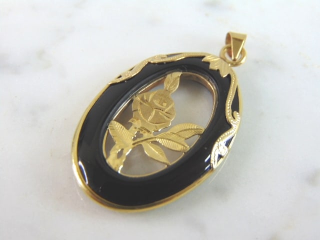 Womens Vintage Estate 14K Yellow Gold Flower Pendant: A WOMEN'S VINTAGE ESTATE 14K YELLOW GOLD FLOWER PENDANT THAT MEASURES 1 1/2" LONG BY 7/8" WIDE, AND WEIGHS 3.7g. THE BLACK PART APPEARS TO BE MADE OF ONYX. PENDANT IS MARKED 14K ON THE BALE. MAKES A L