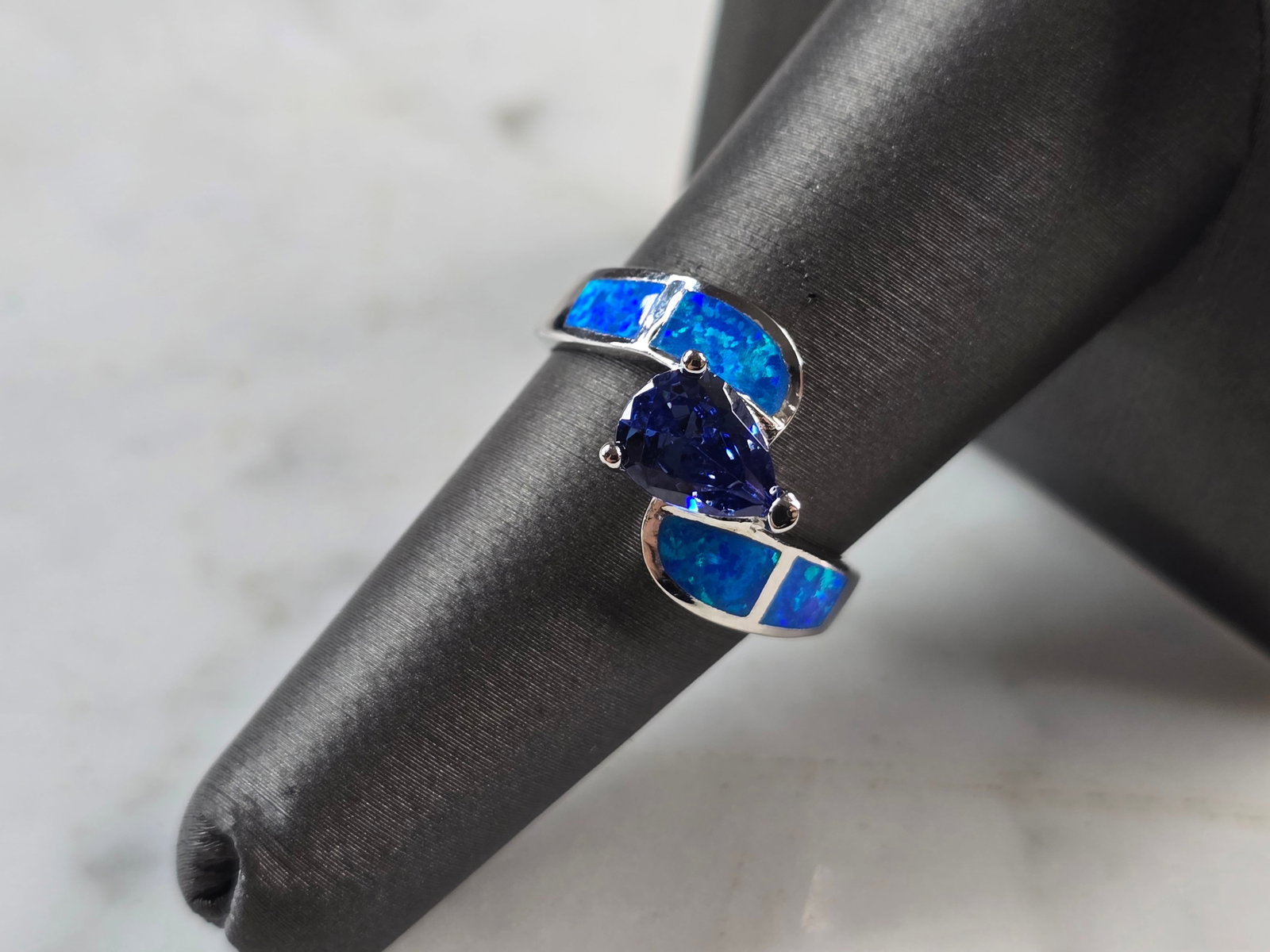 Womens Sterling Silver Blue Opal Tanzanite Modernist Ring: A WOMENS STERLING SILVER BLUE OPAL & TANZANITE COLORED MODERNIST RING. THE RING IS A SIZE 7.0, AND WEIGHS 3.9g. WIDTH OF RING MEASURES 1/2". NOT SURE IF STONE IS NATURAL OR MAN MADE. THE RING MAKES A 