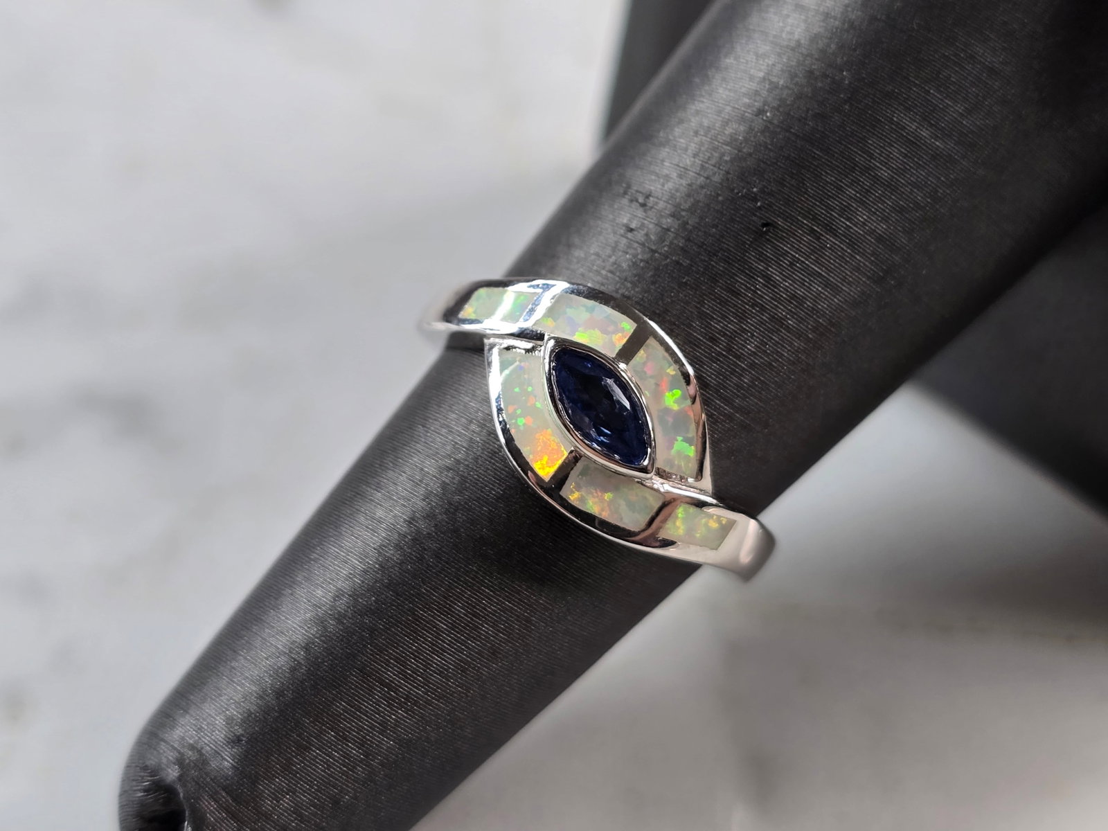 Womens Sterling Silver Opal Tanzanite Modernist Ring: A WOMENS STERLING SILVER OPAL & TANZANITE COLORED MODERNIST RING. THE RING IS A SIZE 6.0, AND WEIGHS 3.6g. WIDTH OF RING MEASURES 3/8". NOT SURE IF STONE IS NATURAL OR MAN MADE. THE RING MAKES A BEAUT