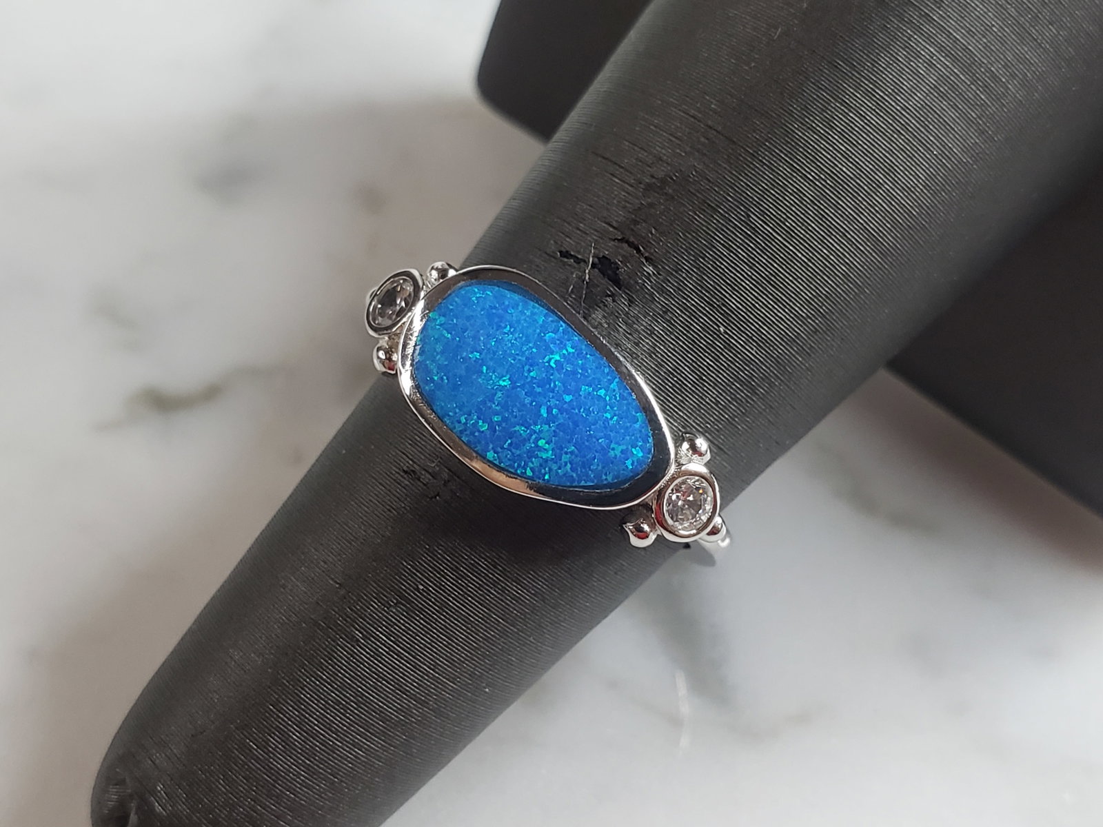 Womens Estate Sterling Silver Modernist Blue Opal Ring: A WOMENS ESTATE STERLING SILVER MODERNIST BLUE OPAL COLORED RING. THE RING IS A SIZE 6.25 AND WEIGHS 3.3g. WIDTH OF RING MEASURES 3/8". NOT SURE IF STONE IS NATURAL OR MAN MADE. THE RING MAKES A BEAUT