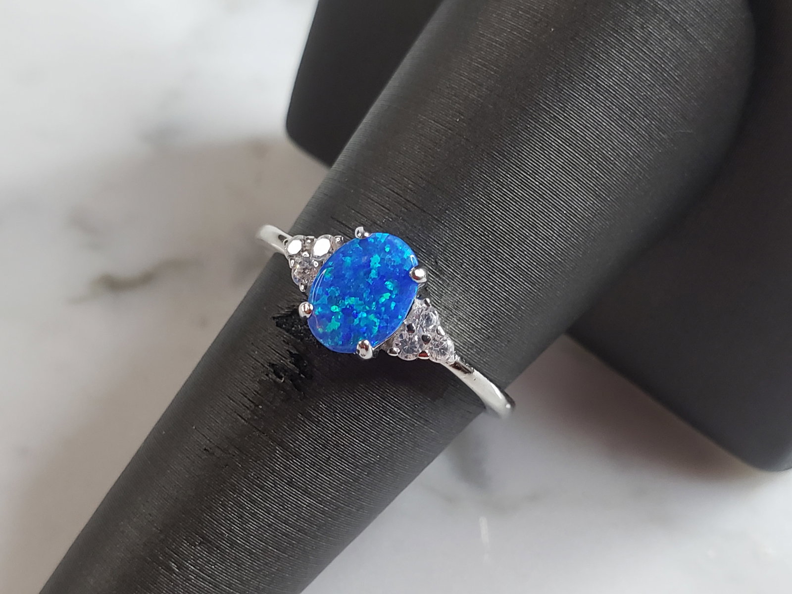 Womens Sterling Silver Modernist Blue Opal Ring: A WOMENS STERLING SILVER MODERNIST BLUE OPAL COLORED RING. THE RING IS A SIZE 8.0, AND WEIGHS 2.2g. WIDTH OF RING MEASURES 3/8". NOT SURE IF STONE IS NATURAL OR MAN MADE. THE RING MAKES A BEAUTIFUL GI