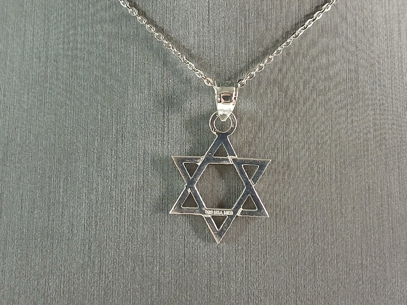 Sterling Silver Jewish Judaica Star of David Pendant Necklace: A STERLING SILVER STAR OF DAVID PENDANT WITH NECKLACE. THE PENDANT WITH NECKLACE WEIGHS 3.0g. THE NECKLACE MEASURES 18" LONG, AND IS ADJUSTABLE TO 16" LONG. THE PENDANT MEASURES 1" LONG BY 3/4" WIDE. 