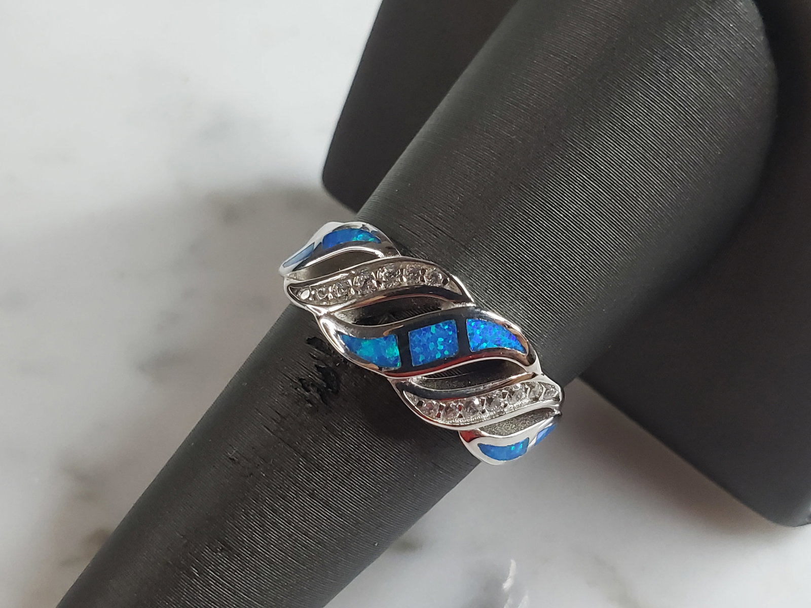 Womens Estate Sterling Silver Modernist Blue Opal & CZ Ring: A WOMENS ESTATE STERLING SILVER MODERNIST BLUE OPAL COLORED RING. THE RING IS A SIZE 8.0 AND WEIGHS 4.7g. WIDTH OF RING MEASURES 3/8". NOT SURE IF STONE IS NATURAL OR MAN MADE. THE RING MAKES A BEAUTI