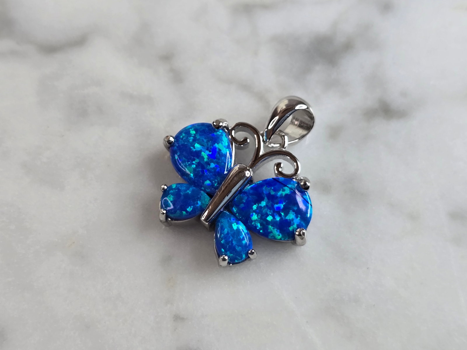 Womens Sterling Silver Blue Opal Butterfly Pendant: A WOMENS ESTATE STERLING SILVER BLUE OPAL BUTTERFLY PENDANT. NOT SURE IF STONES ARE REAL OR MAN MADE. THE PENDANT WEIGHS 2.9g, AND MEASURES 3/4" LONG BY 5/8" WIDE. MAKES A GREAT GIFT FOR THAT SOMEONE 