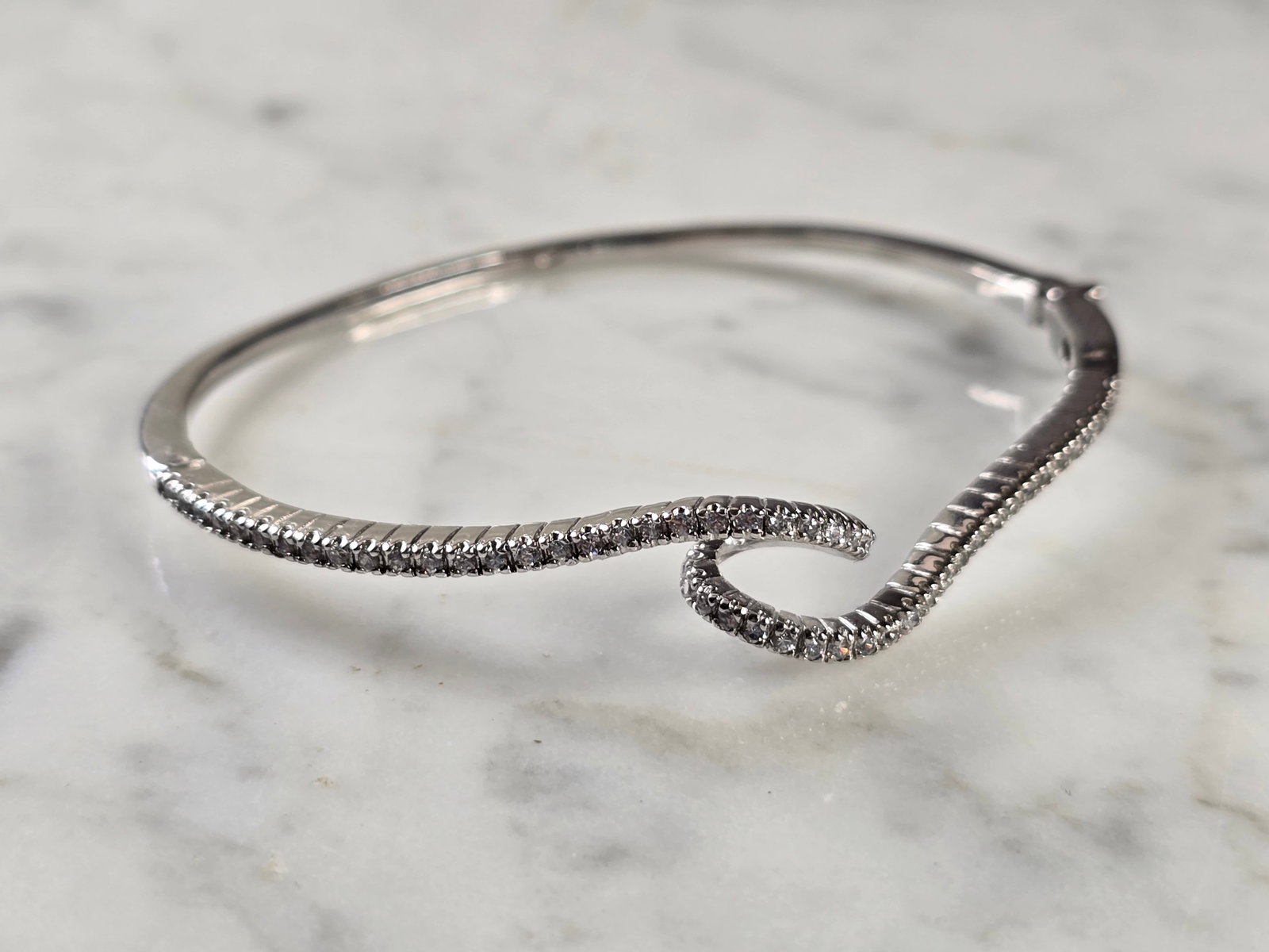 Womens Vintage Estate Sterling Silver CZ Wave Bangle Bracelet: A WOMENS VINTAGE ESTATE STERLING SILVER CZ WAVE BANGLE BRACELET. BRACELET MEASURES 6 1/2" IN CIRCUMFERENCE BY 3/8" WIDE, AND WEIGHS 10.6g. WOULD MAKE A LOVELY GIFT FOR THAT SOMEONE SPECIAL. BE SURE TO