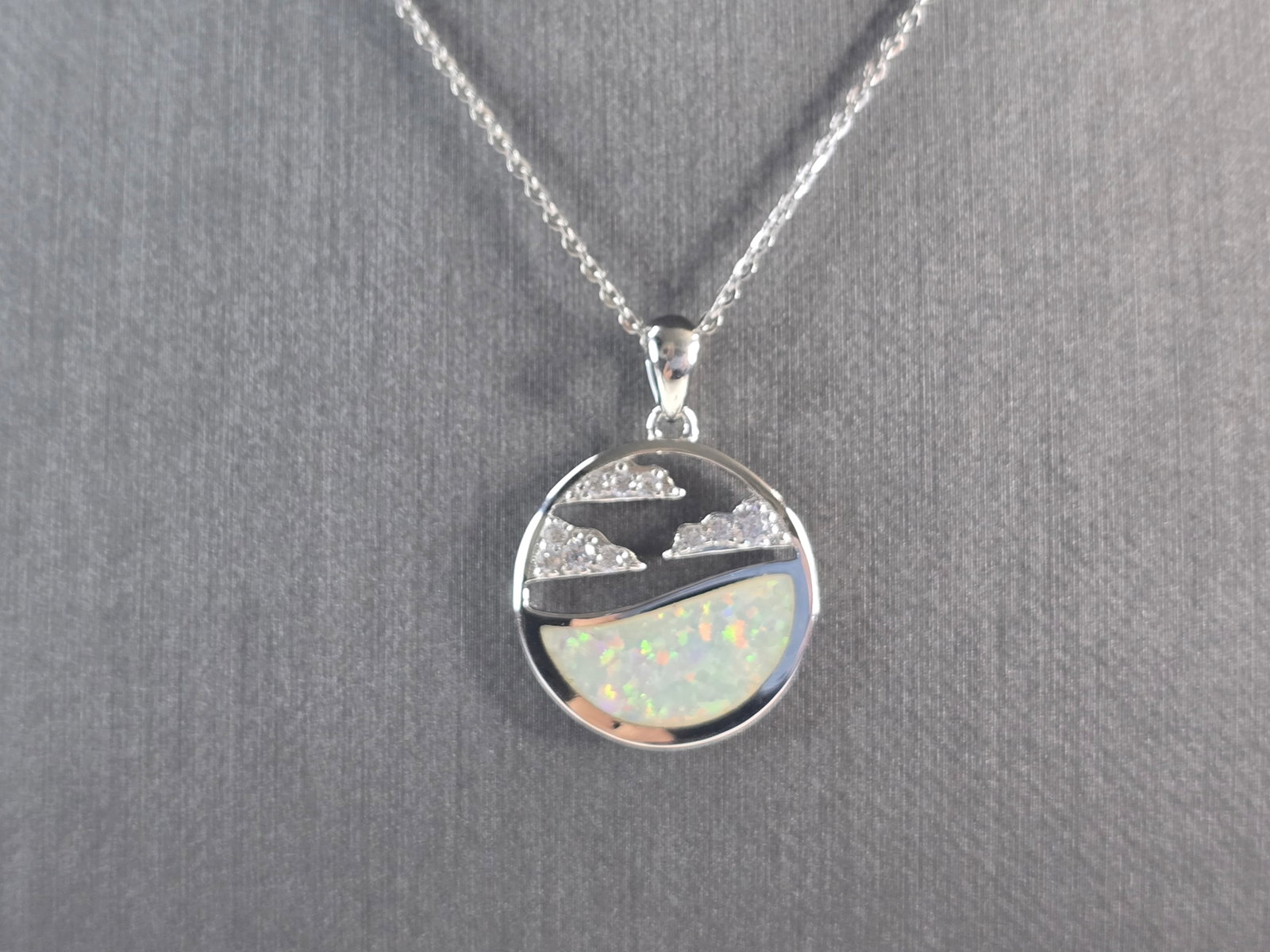 Womens Sterling Silver Opal Ocean Wave Cloud Pendant Necklace: A WOMENS STERLING SILVER OPAL OCEAN , WAVE, CLOUD PENDANT WITH NECKLACE. THE PENDANT WITH NECKLACE WEIGHS 5.7g. THE PENDANT MEASURES 1" LONG BY 3/4" WIDE, AND THE NECKLACE MEASURES 18" LONG, ADJUSTABL