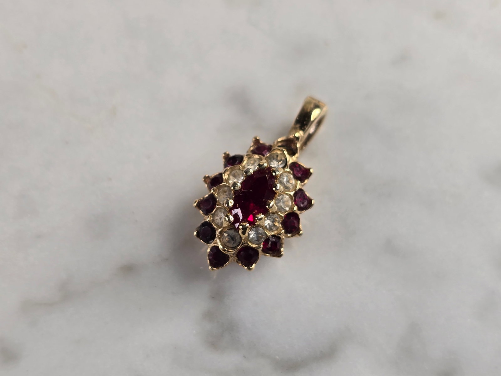Womens Vintage Estate 14k Yellow Gold CZ Pendant: A WOMENS VINTAGE ESTATE 14K YELLOW GOLD PENDANT WITH RUBY COLORED STONES ACCENTED WITH CZ. PENDANT MEASURES 5/8" LONG BY 3/8" WIDE, AND WEIGHS 1.3g. PENDANT IS NOT MARKED BUT HAS BEEN TESTED AND IS GU