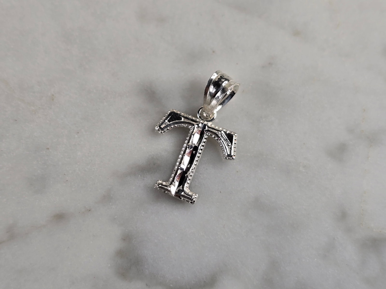Womens Sterling Silver Initial Letter " T " Pendant: A WOMENS STERLING SILVER INITIAL LETTER "T" PENDANT. PENDANT WEIGHS 0.3g AND MEASURES 5/8" LONG BY 3/8" WIDE. MAKES A GREAT GIFT FOR THAT SOMEONE SPECIAL. ANY QUESTIONS, PLEASE ASK. BE SURE TO CHECK