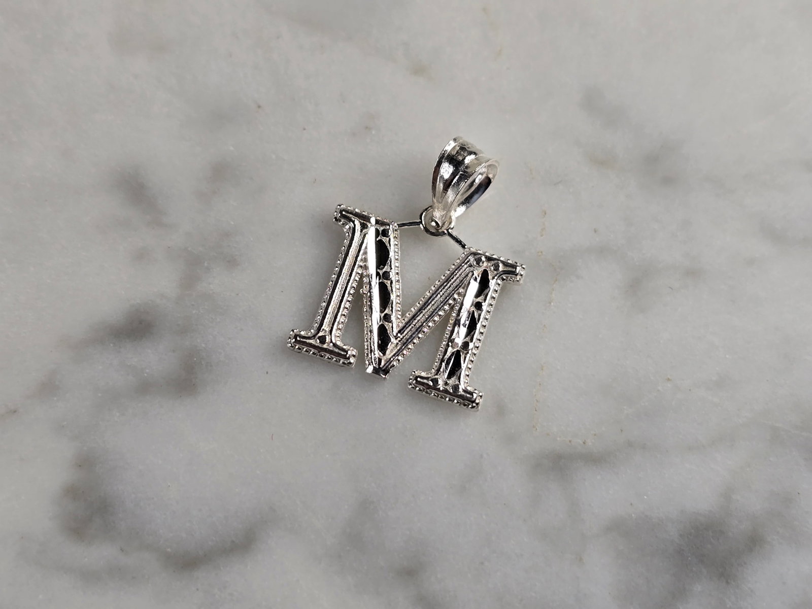 Womens Sterling Silver Initial Letter " M " Pendant: A WOMENS STERLING SILVER INITIAL LETTER "M" PENDANT. PENDANT WEIGHS 0.3g AND MEASURES 5/8" LONG BY 3/8" WIDE. MAKES A GREAT GIFT FOR THAT SOMEONE SPECIAL. ANY QUESTIONS, PLEASE ASK. BE SURE TO CHECK