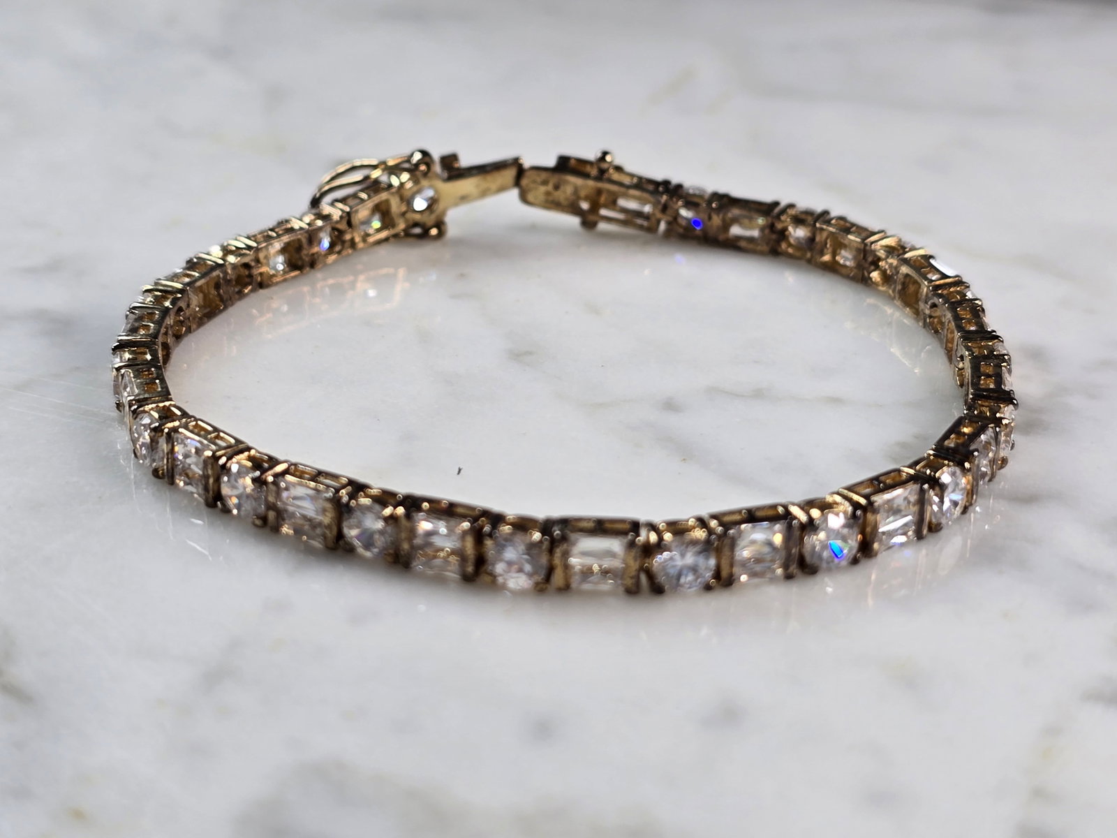 Womens Vintage Estate Sterling Silver CZ Gold Tone Tennis Bracelet: A WOMENS VINTAGE ESTATE STERLING SILVER GOLD TONE WOMENS TENNIS BRACELET WITH CZ STONES. THE BRACELET MEASURES 7" LONG BY 1/4" WIDE, AND WEIGHS 13.7g. WOULD MAKE A GREAT GIFT FOR THAT SPECIAL SOMEONE.