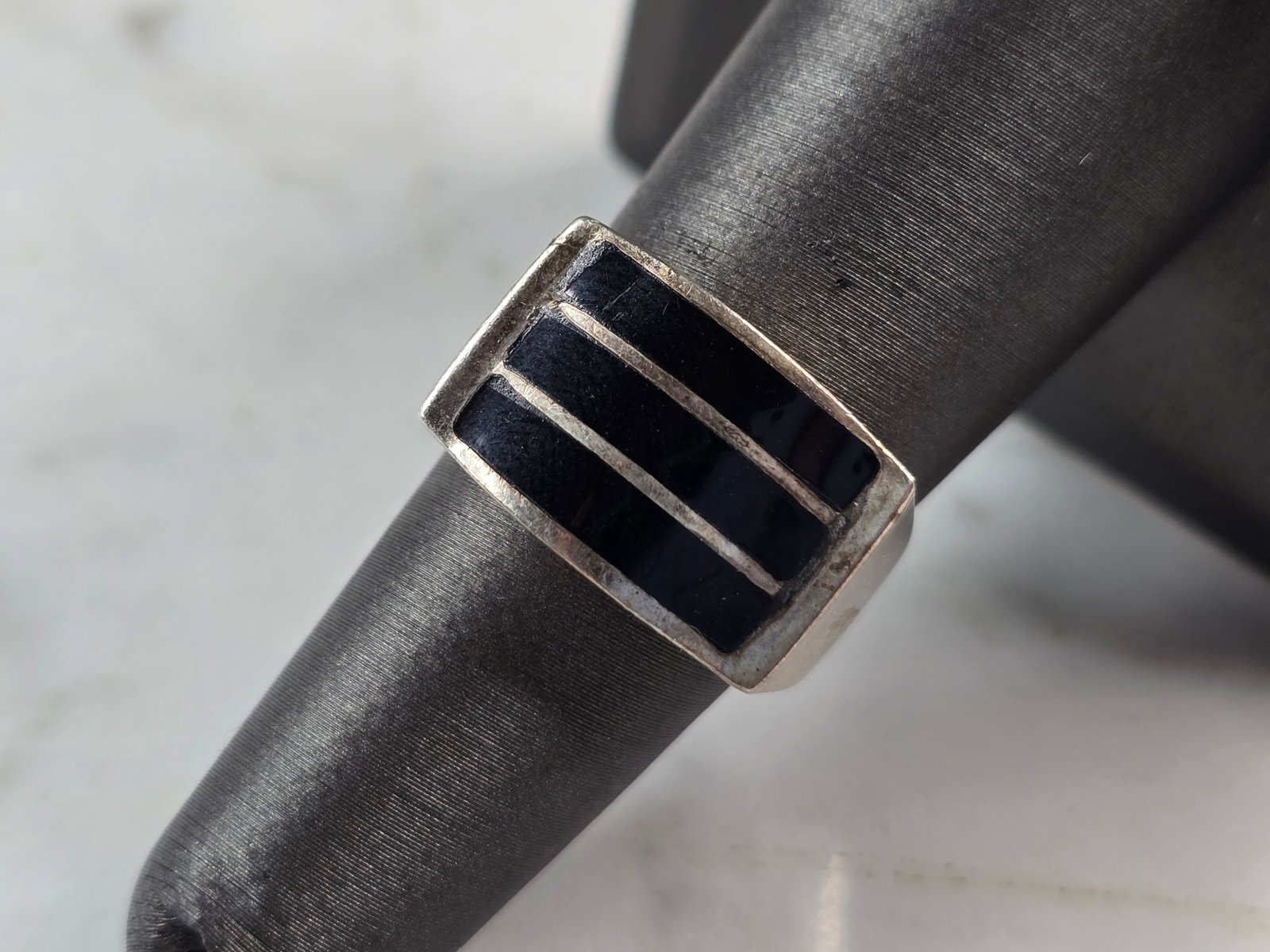 Womens Vintage Estate Sterling Silver Modernist Onyx Ring: A WOMENS VINTAGE ESTATE STERLING SILVER MODERNIST ONYX RING. RING SIZE IS 6.75, AND WEIGHS 5.1g. THE WIDTH OF THE RING IS 3/8". THIS WOULD MAKE A NICE GIFT FOR THAT SOMEONE SPECIAL. ANY QUESTIONS PLEA