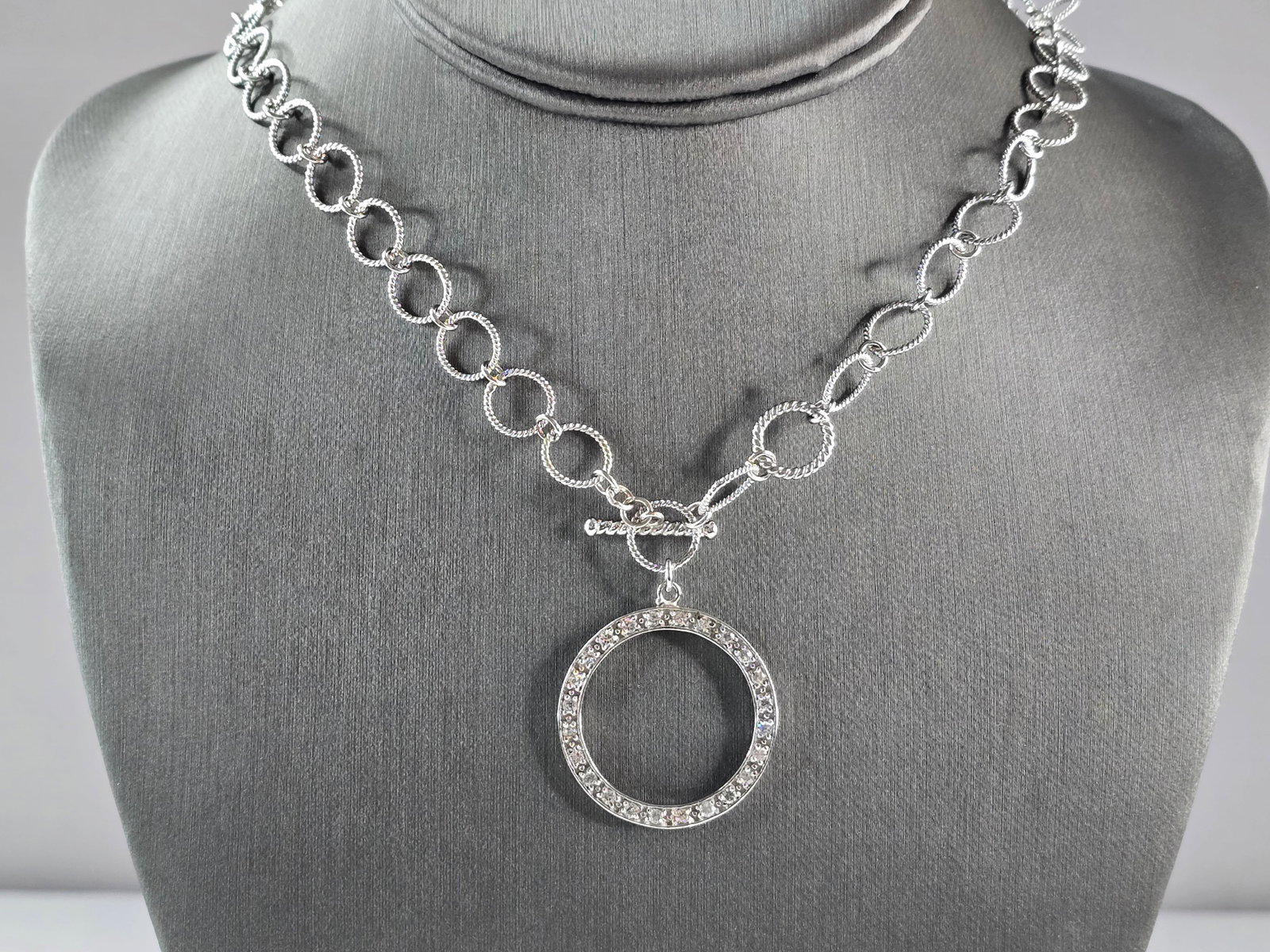 Womens Sterling Silver Modernist CZ Eternity Circle Necklace: A WOMENS STERLING SILVER MODERNIST CZ ETERNITY CIRCLE NECKLACE. NECKLACE WEIGHS 18.6g, AND MEASURES 19" LONG BY 1 1/4" WIDE. PENDANT IS NOT MARKED BUT IT HAS BEEN TESTED AND IS GUARANTEED TO BE AS DES