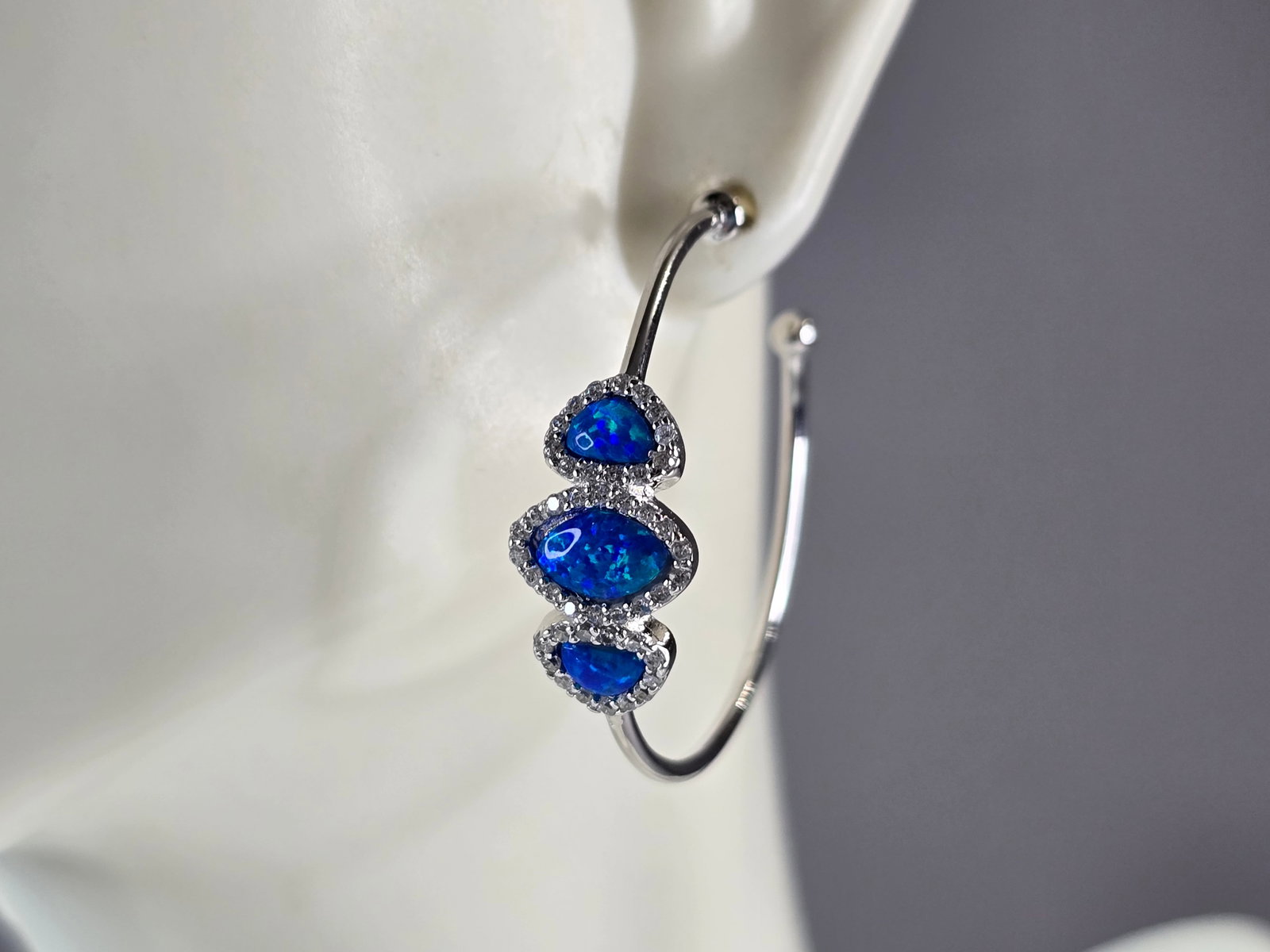 Womens Sterling Silver Modernist Blue Opal Hoop Earrings: A PAIR OF WOMENS STERLING SILVER BLUE OPAL COLORED EARRINGS THAT WEIGH 4.9g AND MEASURES 1 1/4" LONG BY 3/8" WIDE. NOT SURE IF STONES ARE NATURAL OR MAN MADE. ANY QUESTIONS, PLEASE DO NOT HESITATE TO 