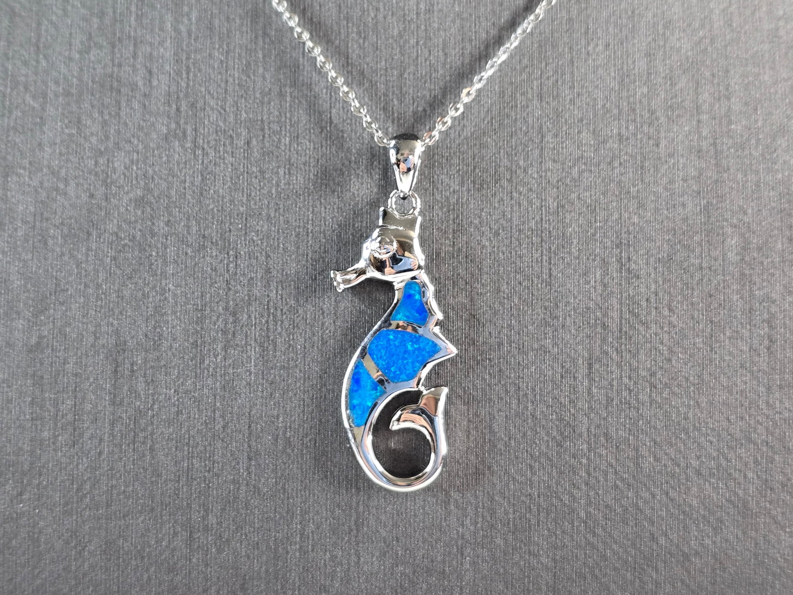 Womens Sterling Silver Blue Opal Seahorse Pendant Necklace: A WOMENS STERLING SILVER BLUE OPAL SEAHORSE PENDANT. THE PENDANT WITH NECKLACE WEIGHS 5.5g. THE PENDANT MEASURES 1 1/4" LONG BY 1/2" WIDE, AND THE NECKLACE MEASURES 18" LONG, ADJUSTABLE TO 16" LONG. N