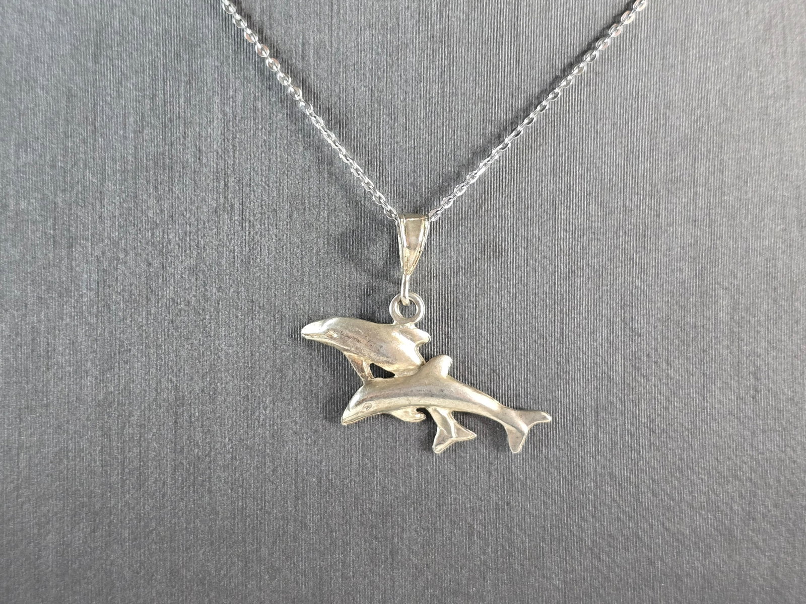 Womens Vintage Estate Sterling Silver Dolphin Pendant Necklace: A WOMENS VINTAGE ESTATE STERLING SILVER DOLPHIN PENDANT WITH NECKLACE. THE PENDANT AND NECKLACE WEIGHS 3.9g. THE NECKLACE MEASURES 18" LONG, AND THE PENDANT MEASURES 1" LONG BY 1 1/8" WIDE. MAKES A GR