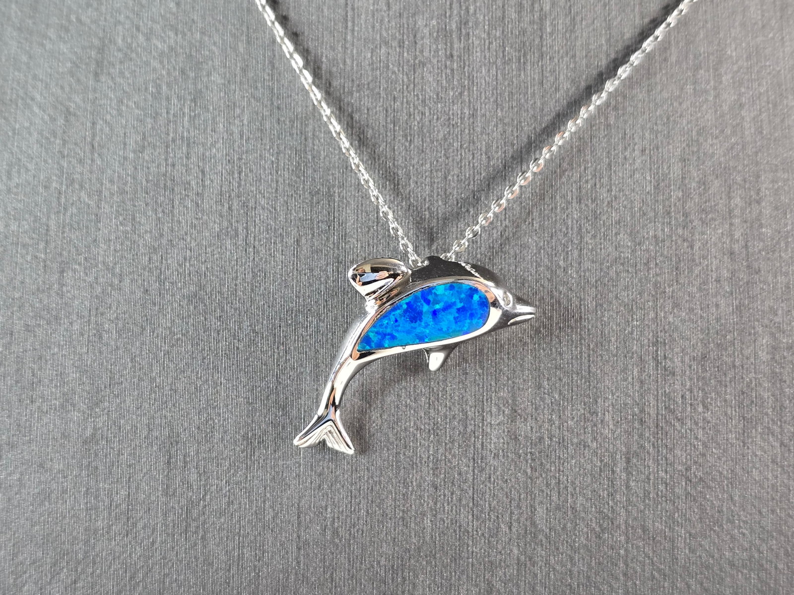Womens Sterling Silver Blue Opal Dolphin Pendant Necklace: A WOMENS STERLING SILVER BLUE OPAL DOLPHIN PENDANT. THE PENDANT WITH NECKLACE WEIGHS 4.3g. THE PENDANT MEASURES 1" LONG BY 1/2" WIDE. THE NECKLACE MEASURES 18" LONG AND IS ADJUSTABLE TO 16" LONG. NOT 