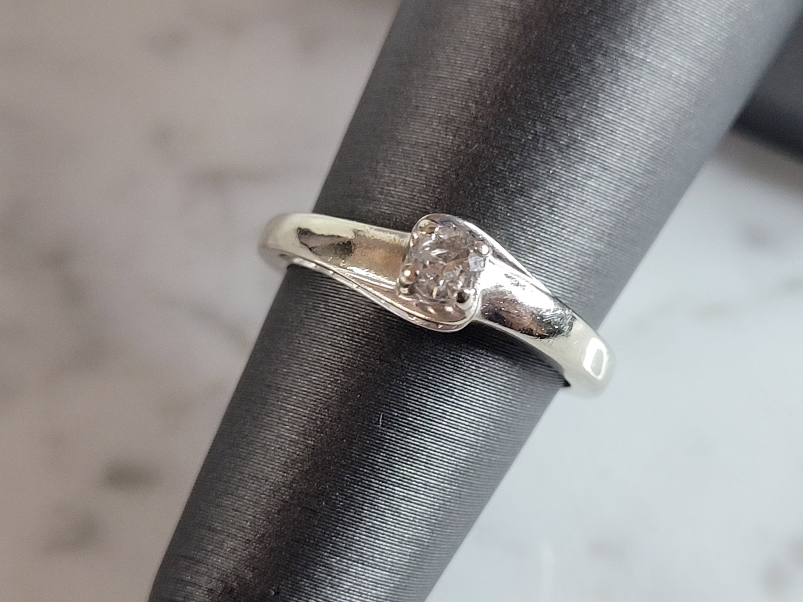 Womens Vintage Estate 10k White Gold Diamond Ring: A WOMENS VINTAGE ESTATE 10K WHITE GOLD DIAMOND RING. THE SIZE OF THE RING IS A 4.75, AND WEIGHS 2.3g. THE CENTER DIAMOND IS ABOUT .15cts, AND THERE ARE 12 TINY ACCENT DIAMONDS. THE WIDTH OF THE RING I