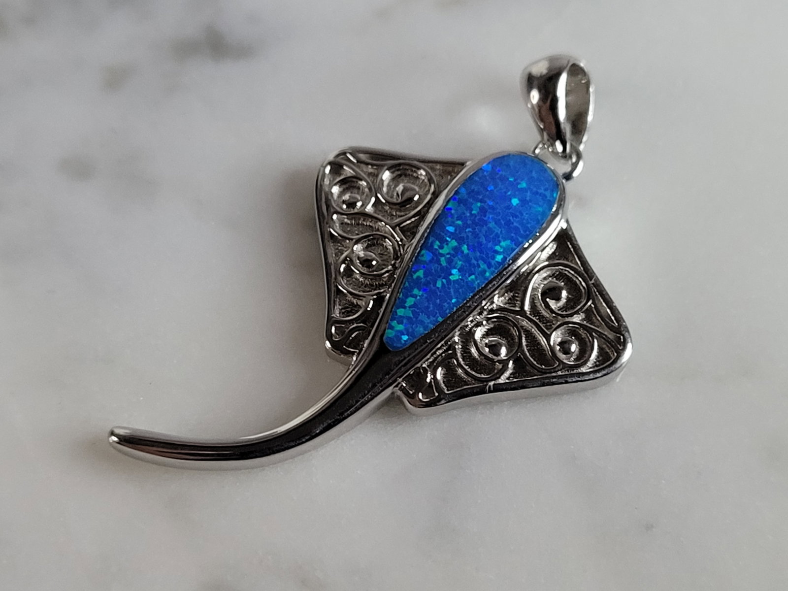 Womens Sterling Silver Blue Opal Manta Stingray Pendant: A WOMENS STERLING SILVER BLUE OPAL STINGRAY PENDANT. NOT SURE IF STONES ARE REAL OR MAN MADE. THE PENDANT WEIGHS 6.4g AND MEASURES 1 3/8" LONG BY 7/8" WIDE. MAKES A GREAT GIFT FOR THAT SOMEONE SPECIAL