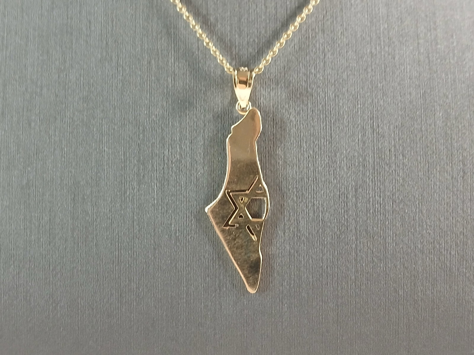 Sterling Silver Gold Tone Jewish Judaica Star of David Pendant: A STERLING SILVER GOLD TONE JUDAICA STAR OF DAVID PENDANT WITH NECKLACE IN THE SHAPE OF ISRAEL. THE PENDANT WITH NECKLACE WEIGHS 3.1g. THE NECKLACE MEASURES 18" LONG, AND THE PENDANT 1 1/2" LONG BY 1/