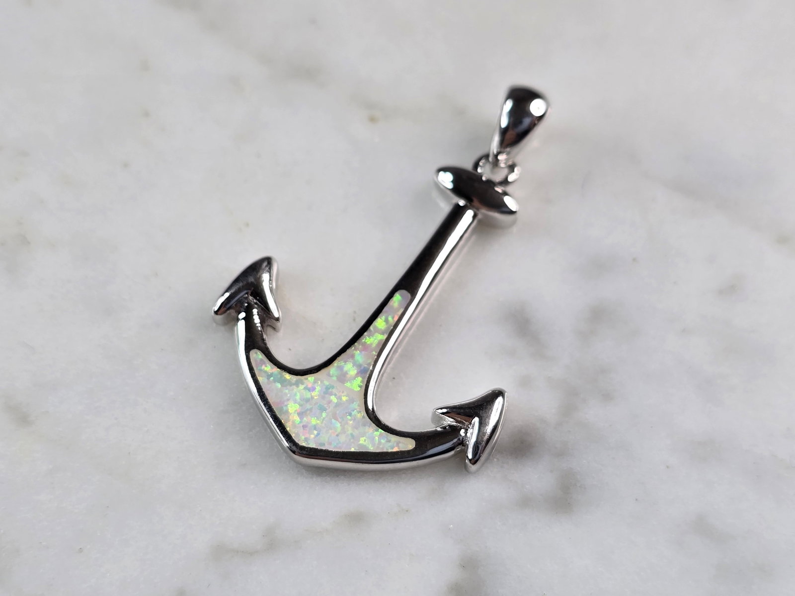 Womens Sterling Silver Opal Maritime Anchor Pendant: A WOMENS STERLING SILVER OPAL MARITIME ANCHOR PENDANT. THE PENDANT WEIGHS 3.0g AND MEASURES 1 1/4" LONG BY 3/4" WIDE. NOT SURE IF STONES ARE NATURAL OR MAN MADE. MAKES A GREAT GIFT FOR THAT SOMEONE SP