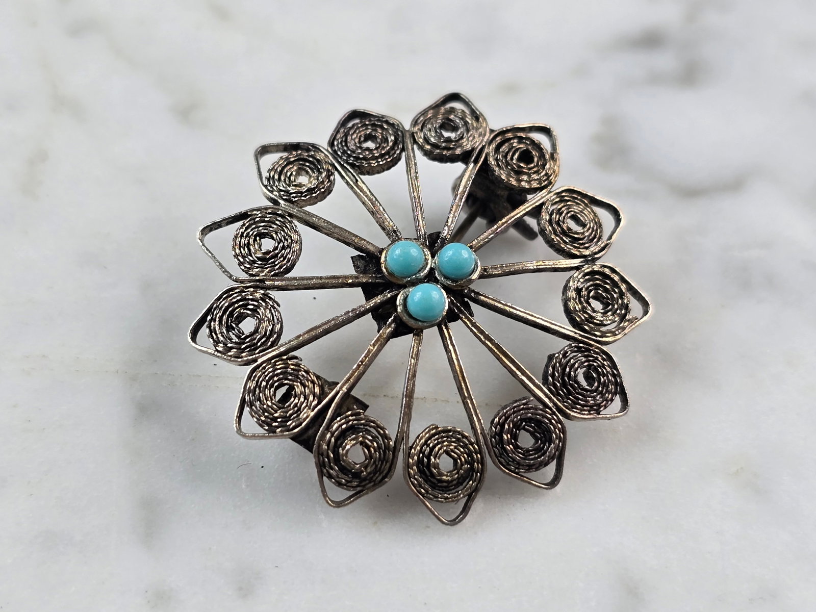 Womens Vintage Estate Sterling Silver Turquoise Filigree Brooch: A WOMENS VINTAGE ESTATE STERLING SILVER TURQUOISE FILIGREE FLORAL BROOCH. THE TOTAL WEIGHT OF THE BROOCH IS 3.7g. THE BROOCH MEASURES 1 1/4" LONG BY 1 1/4" WIDE. NOT SURE IF STONES ARE NATURAL OR MAN 