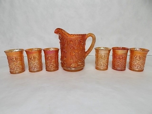 ANTIQUE CARNIVAL GLASS ROSE BUD PITCHER & TUMBLER SET: A LOVELY VINTAGE ANTIQUE ORANGE CARNIVAL GLASS PITCHER & TUMBLER SET THAT HAS A ROSE BUD MOTIF THROUGHOUT. THE PITCHER MEASURES 8 1/4" TALL, AND THE TUMBLERS EACH MEASURE 4 1/4" TALL BY 3 1/4" WIDE. C